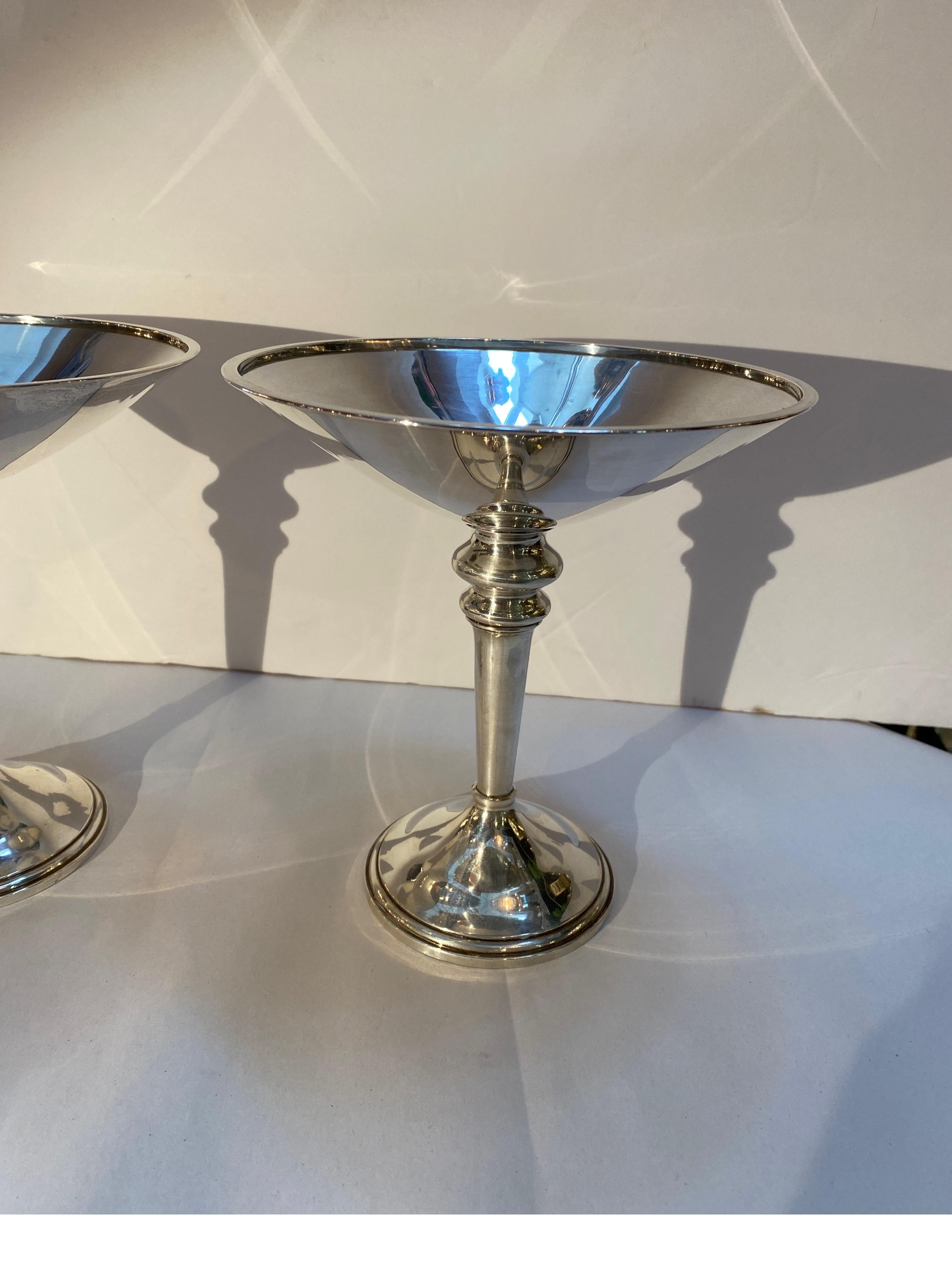 A chic pair of Mid-Century Modern sterling silver footed pedestal compost. The sleek form with balustrade style tapering columns with weighted round bases. These have an oversized martini glass shape. Made by the Elgin Silversmith Company.