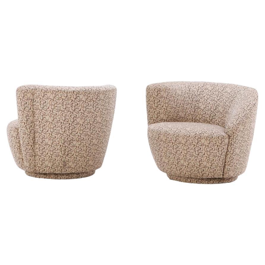 A pair of mid century modern Vladimir Kagan style Nautilus swivel lounge chairs.