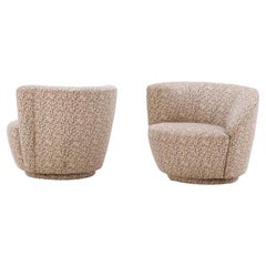 A pair of mid century modern Vladimir Kagan style Nautilus swivel lounge chairs.