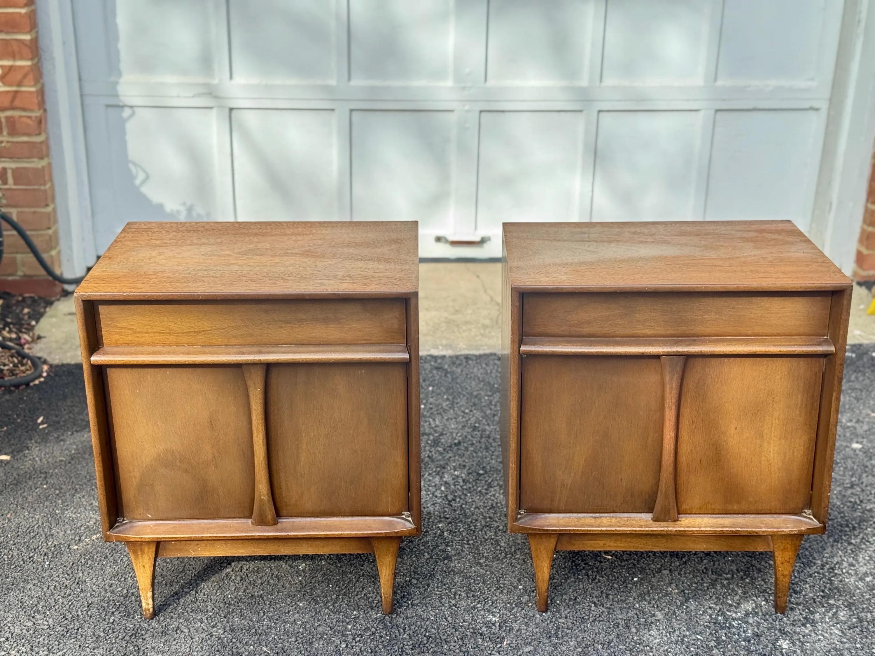Paire de tables de nuit modernes du milieu du siècle par Denck Furniture, New York. Fabriquée en noyer chaud, chaque pièce comporte un tiroir coulissant en douceur sur des portes de placard doubles.
