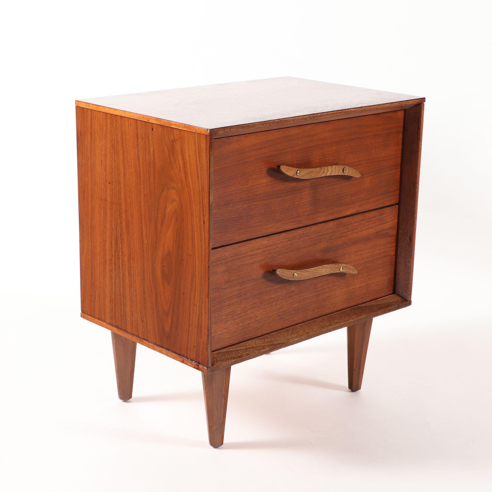 A pair of Mid-Century Modern walnut nightstands having sculptural drawer pulls circa 1960.