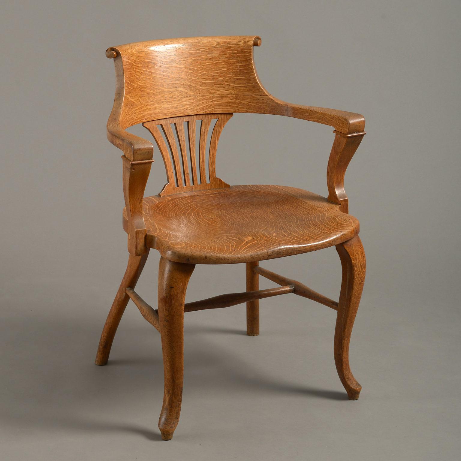 A mid-20th century pair of oak open armchairs, the scrolling back supported by a fluted splat, the finely figured shaped seats raised upon cabriole legs with turned H-form stretchers.

These chairs have been made from the finest oak with rich