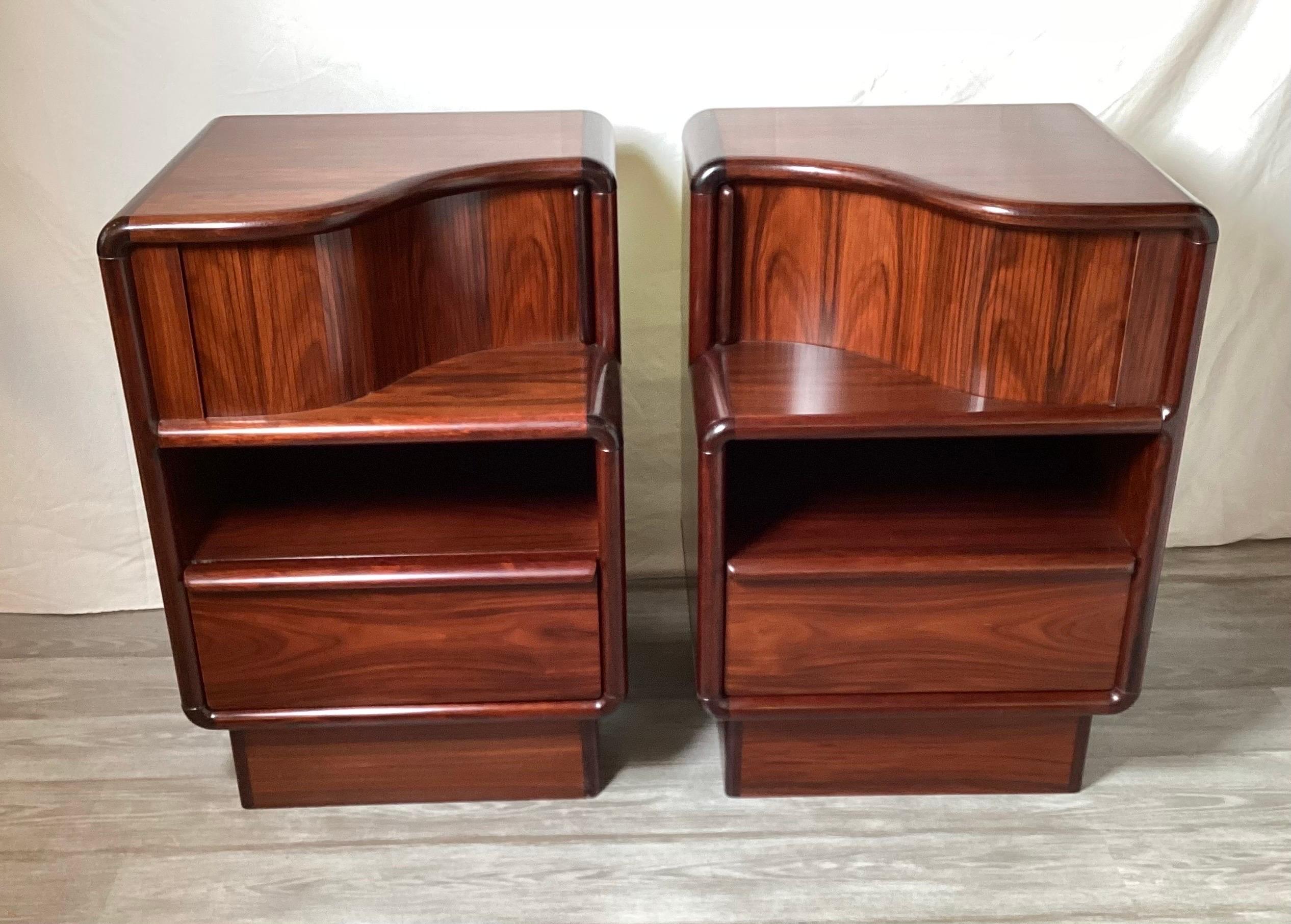 A pair of chic rosewood end tables, night stands with tambour door tops. The well designed chests with storage in three sections, the tambour top, the open shelf center and the drawer at the bottom.