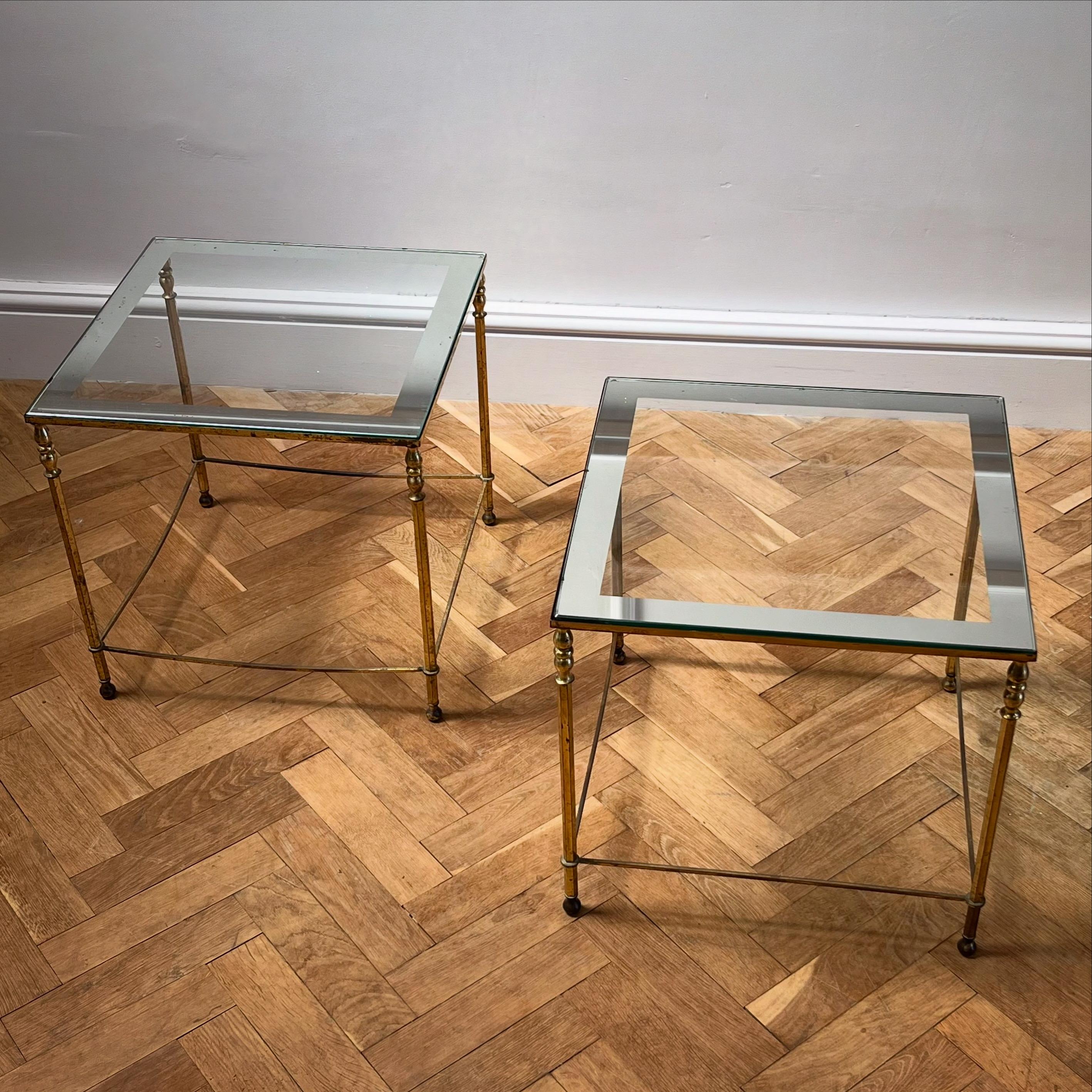 A pair of period brass and glass square tables - mirrored borders to glass tops and octagonal column legs with original patina 

French, Mid Twentieth Century 

H 42.5 x W 45.5 x D 45.5 cms