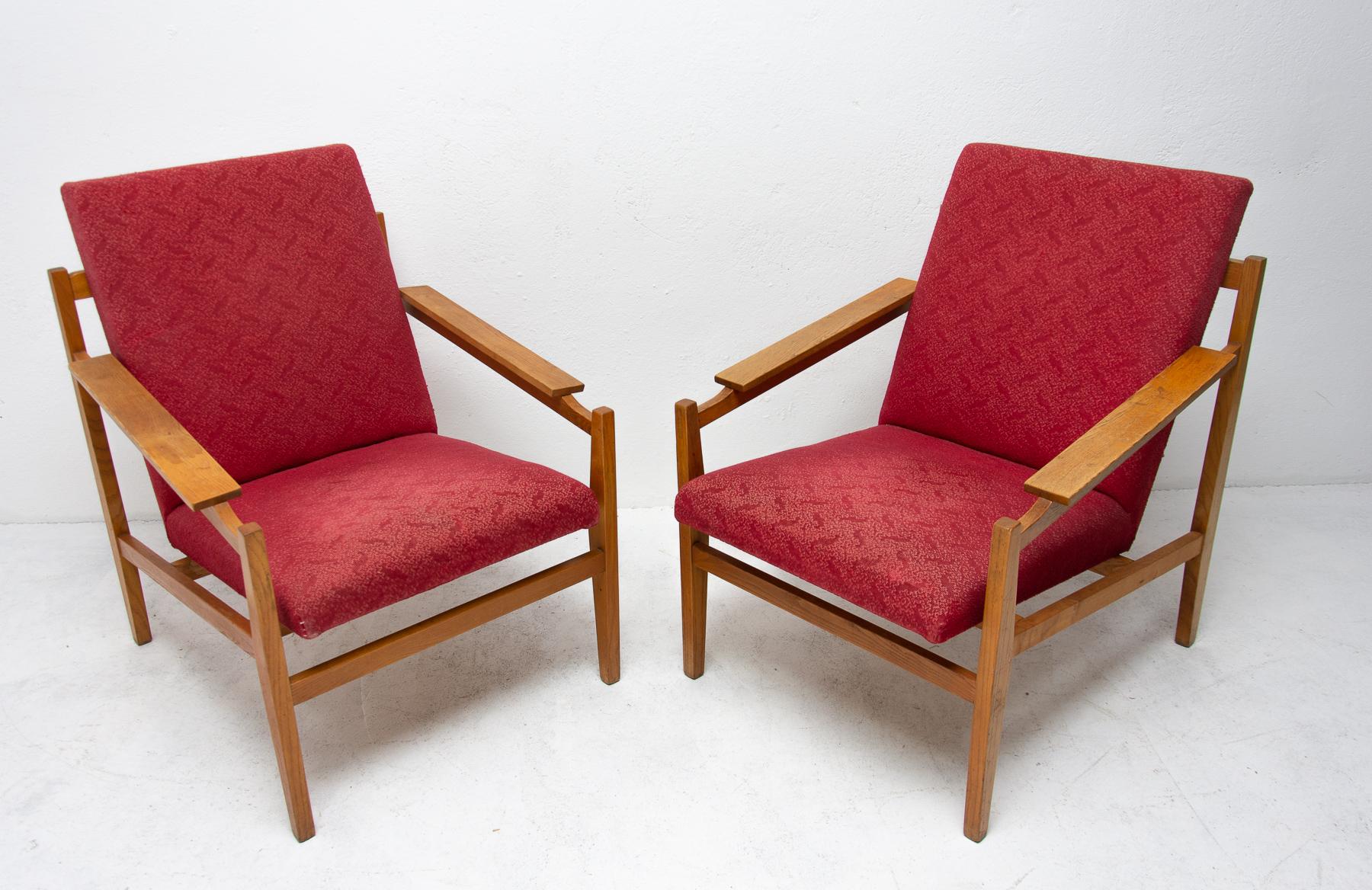 This beautiful pair of midcentury armchairs was produced in the 1960s. It features a beech wood structure and removable cushions in original upholstery. The chairs are fully functional, but it shows sign of age through some abrasions or faded