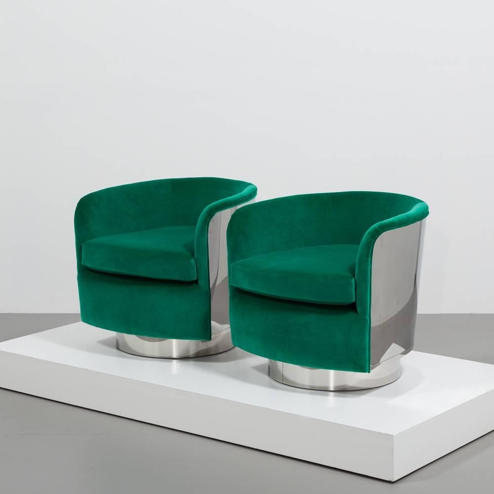 A sensational and rare pair of Milo Baughman designed swivel chairs. Luxoriously wrapped in polished steel and reupholstered in Emerald Green Velvet. The chairs are extremly comfortable, tidy in size, and would compliment any room. These chairs have