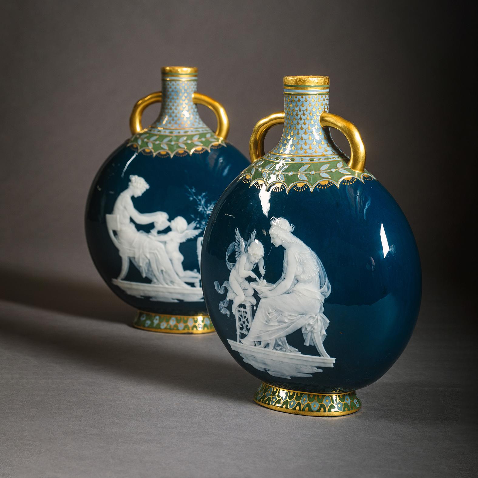 Pareja de frascos de luna azul pavo real Mintons Pâte-sur-pâte, decorados por Marc-Louis-Emmanuel Solon (1835-1913). 

Cifrado de fecha de 1890. Registrada con el nº de forma 1819. Cada uno firmado 