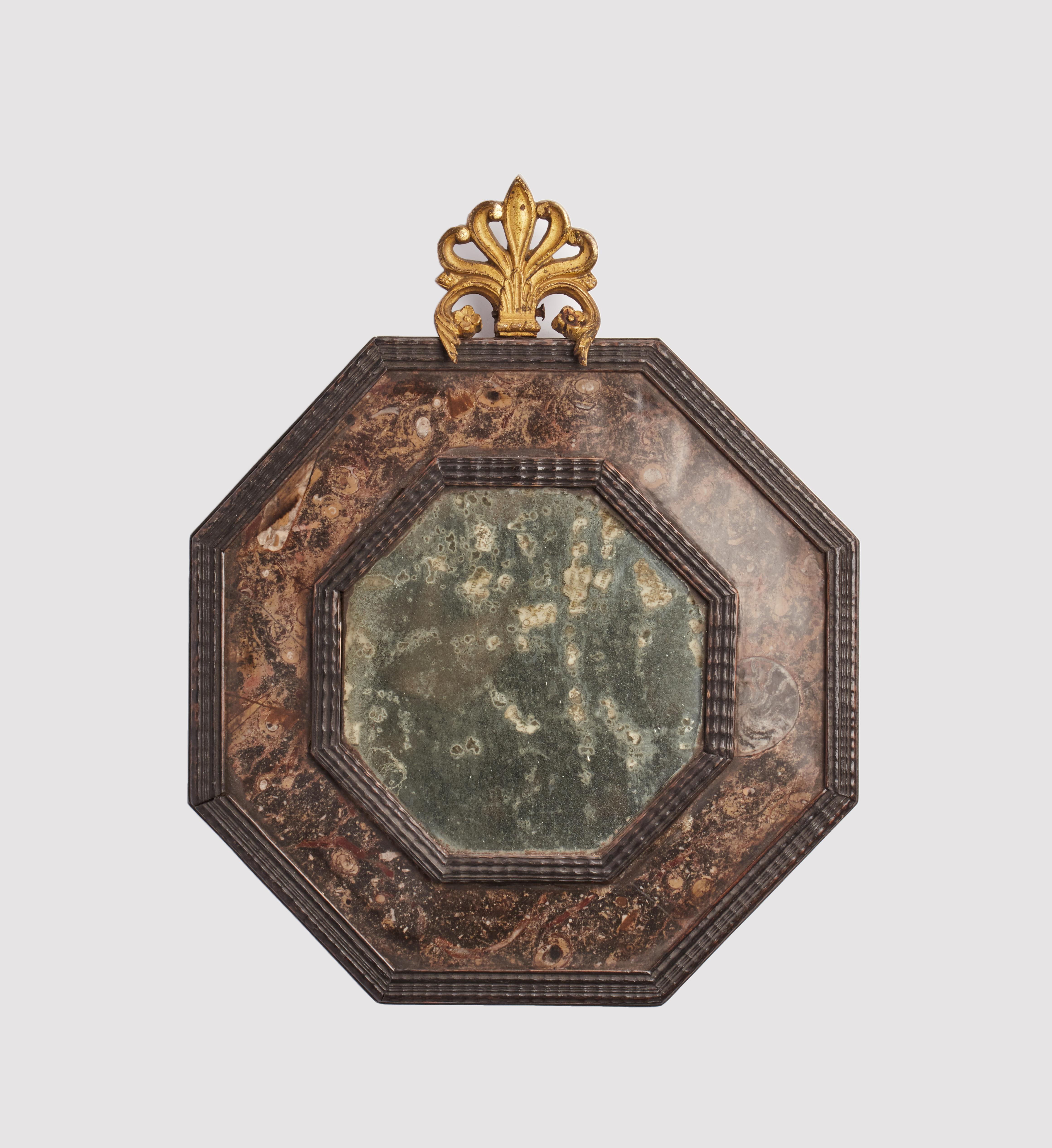A pair of Wunderkammer mirrors, with black wooden octagonal frame, covered with Lumachella stone. Goldgilt brass frieze, Italy, circa 1800.