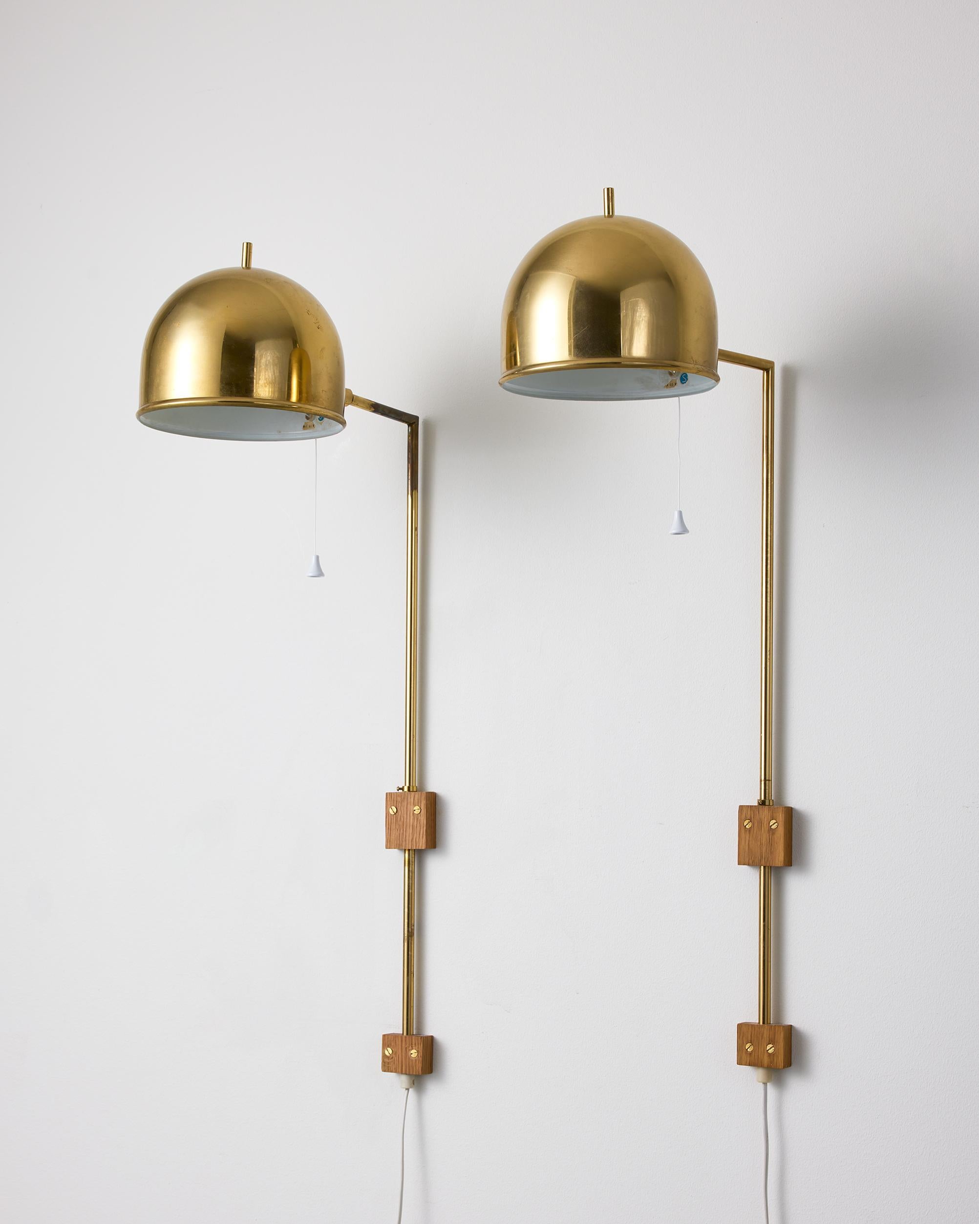 Late 20th Century A pair of model V-75 wall lamps by Eje Ahlgren with Polished Brass Domes For Sale