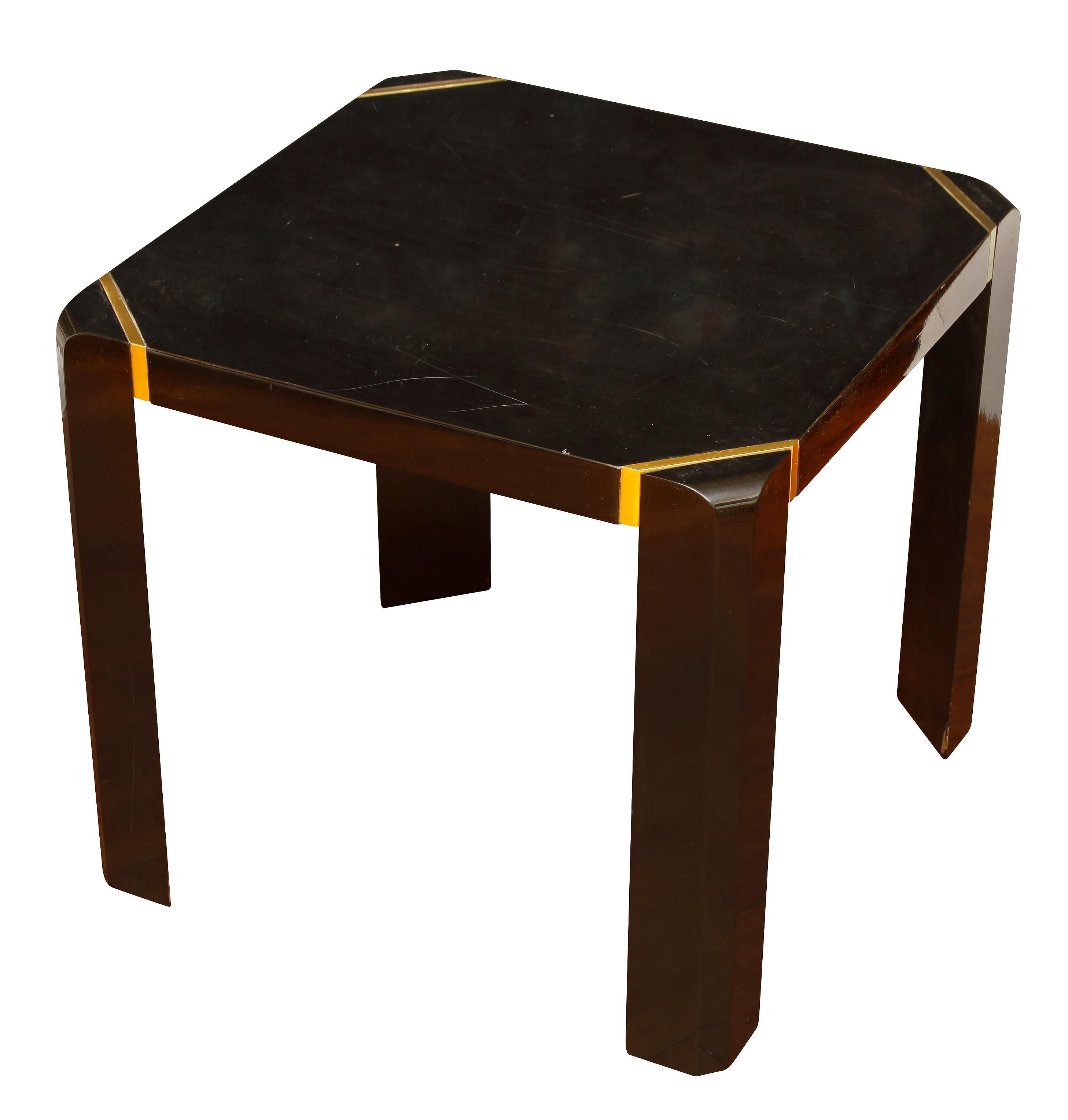 A pair of modern black lacquer side tables with brass details to corners and trim.