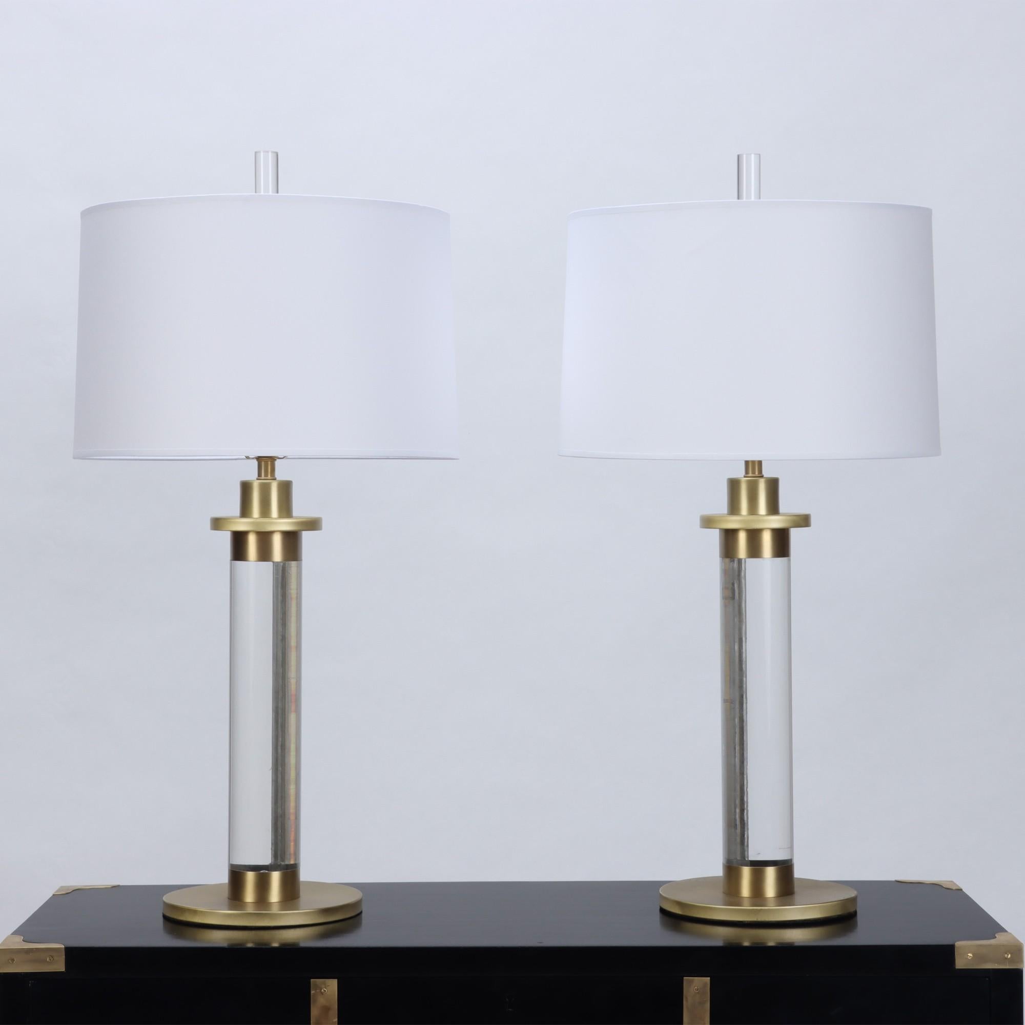A pair of Lucite and Brass column table lamps. Brass re-finished and newly re-wired. Circa 1950.