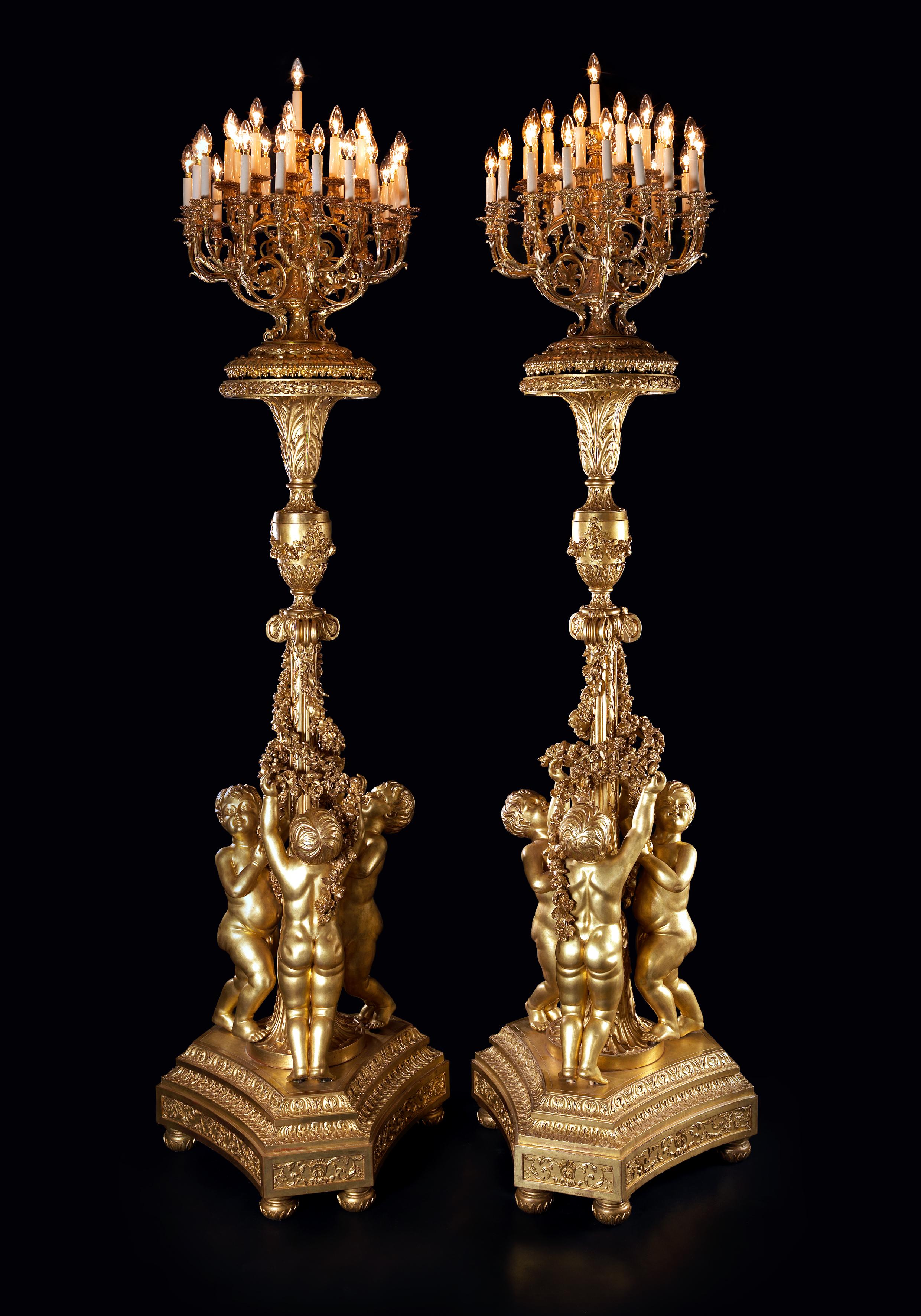 Ein bedeutendes Paar monumentaler Fackeln mit einunddreißig Lichtern aus vergoldetem Holz nach dem Modell von Jacques Gondoin für den Spiegelsaal des Schlosses von Versailles.

Frankreich, um 1870. 
 
Jede Fackel hat einen konkaven Sockel mit