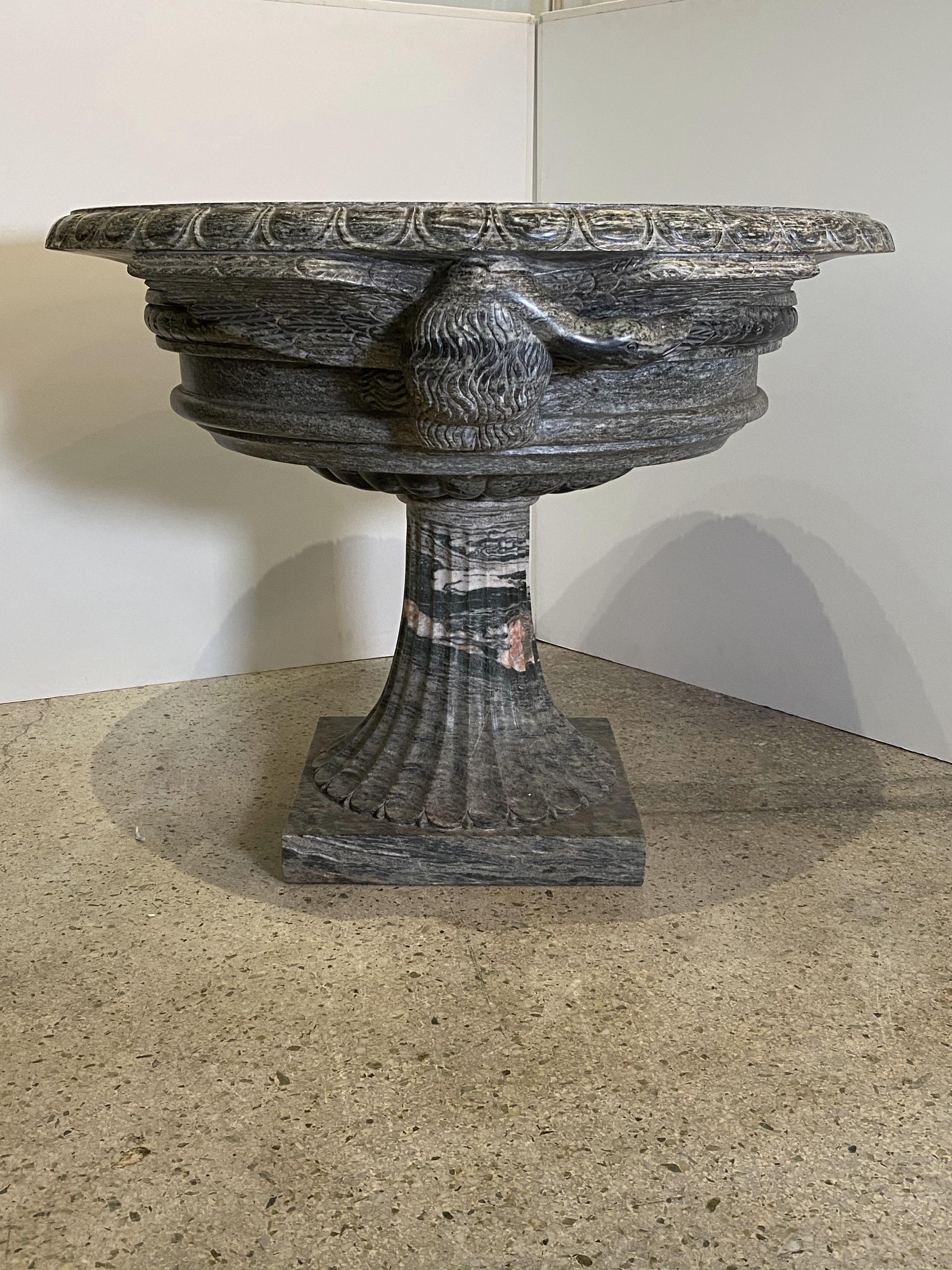 A pair of monumental Italian neoclassic Grand Tour Marmo Grigio Tazza, The rim with ogee carved edge, surrounding a basin, the exterior carved with swans and fluting, on a flaring tapering fluted base, with square plinth.
Superb condition.