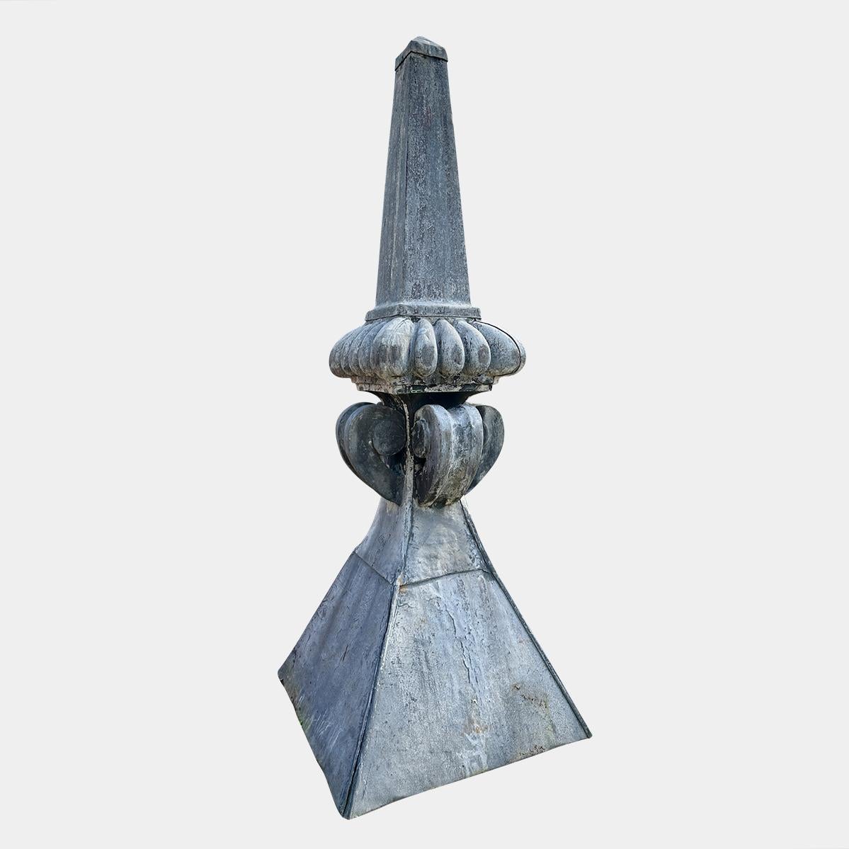 A monumental pair of antique lead obelisk roof top finials, turrets. The pyramid shaped base with scrolled brackets supporting a gadrooned plinth and obelisk finials.  Large and imposing reclaimed from Wilton Place Knightsbridge London. A further 2