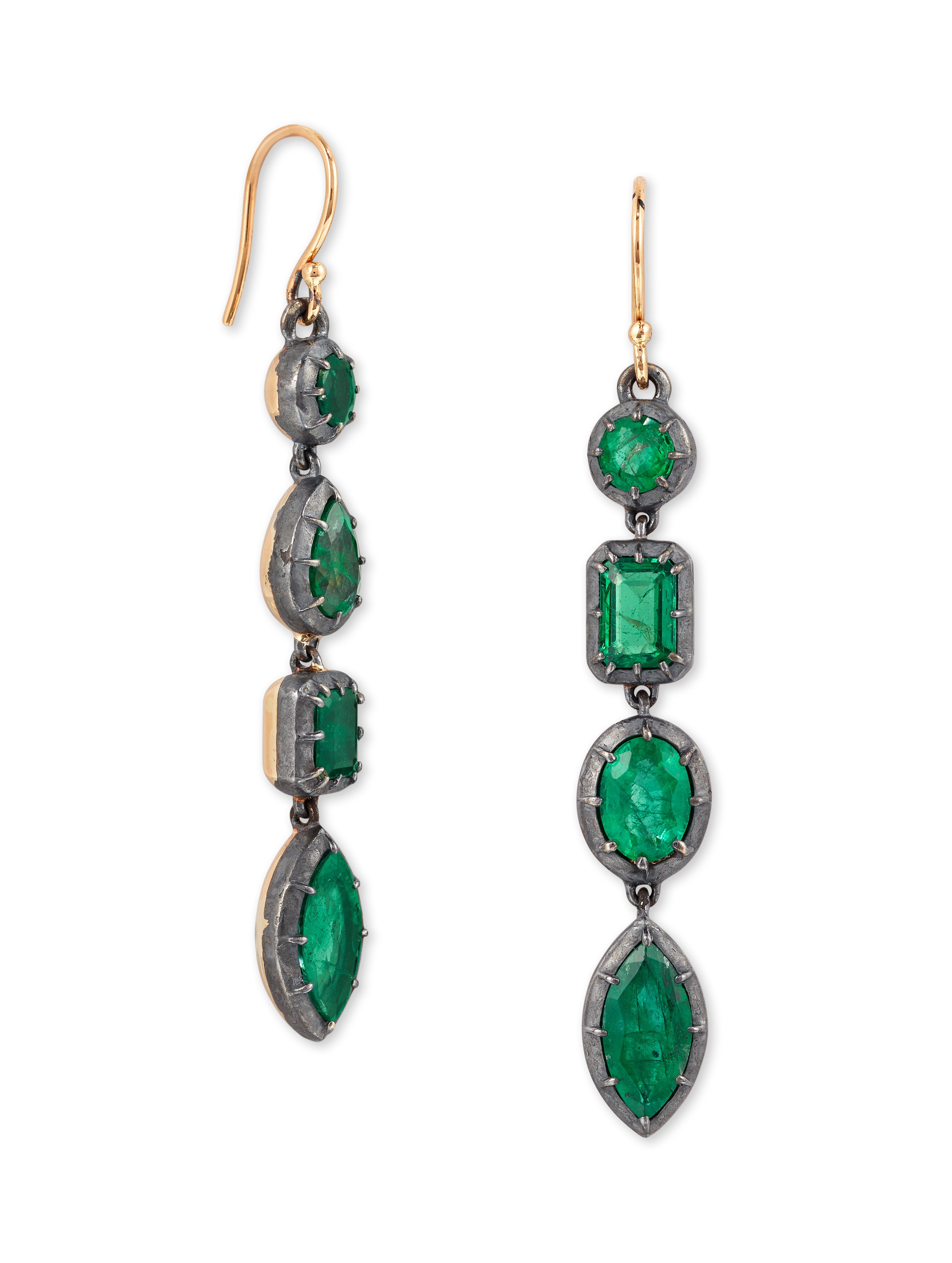 A Beautiful Pair of Emerald Earrings.

Composed of a line of collet set Oval, Square, Marquise and Pair shape Emeralds, with hook fittings mounted in Silver and 18ct gold.