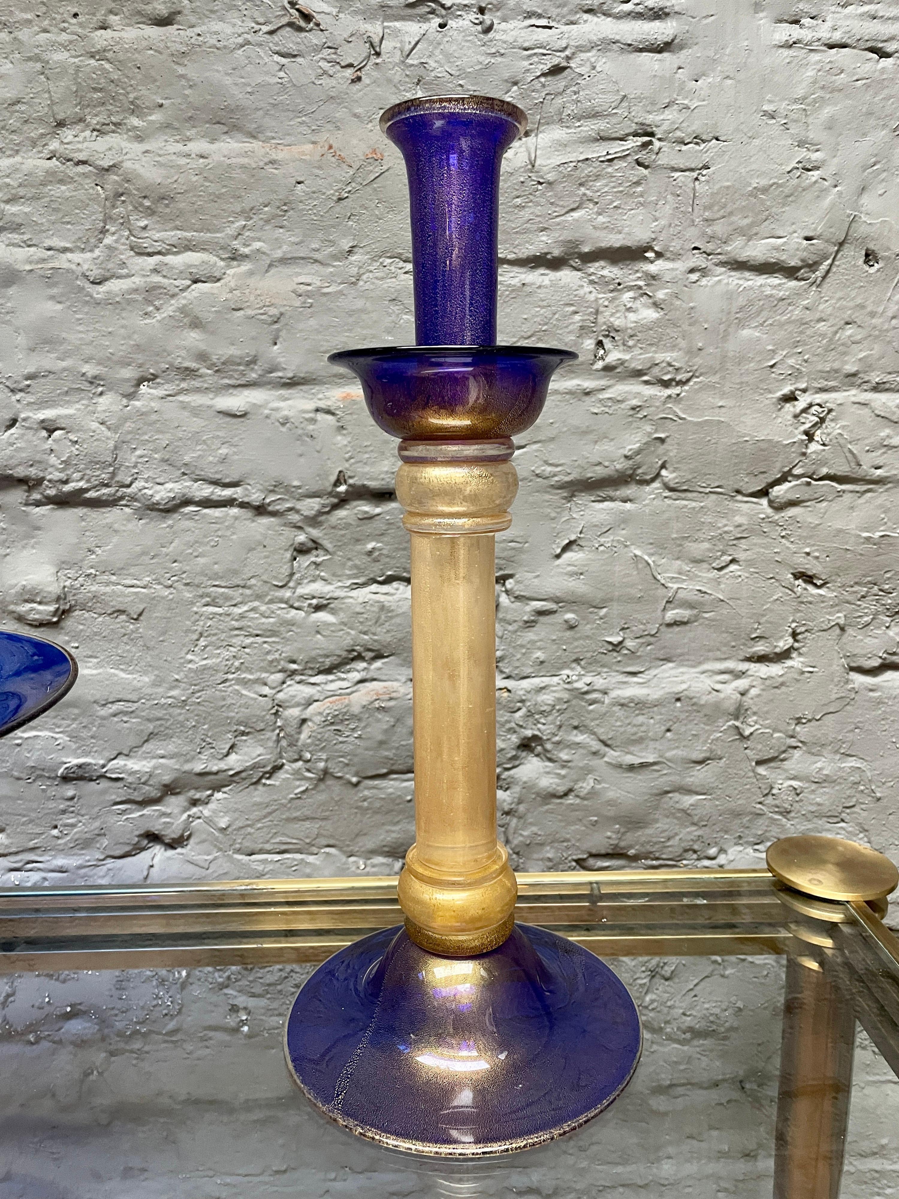 A set of candlesticks and Tazza, in cobalt blue and flecked gold Murano glass, signed and dated by the artist.

Measures: The Tazza is 32cm W x 22cm H.