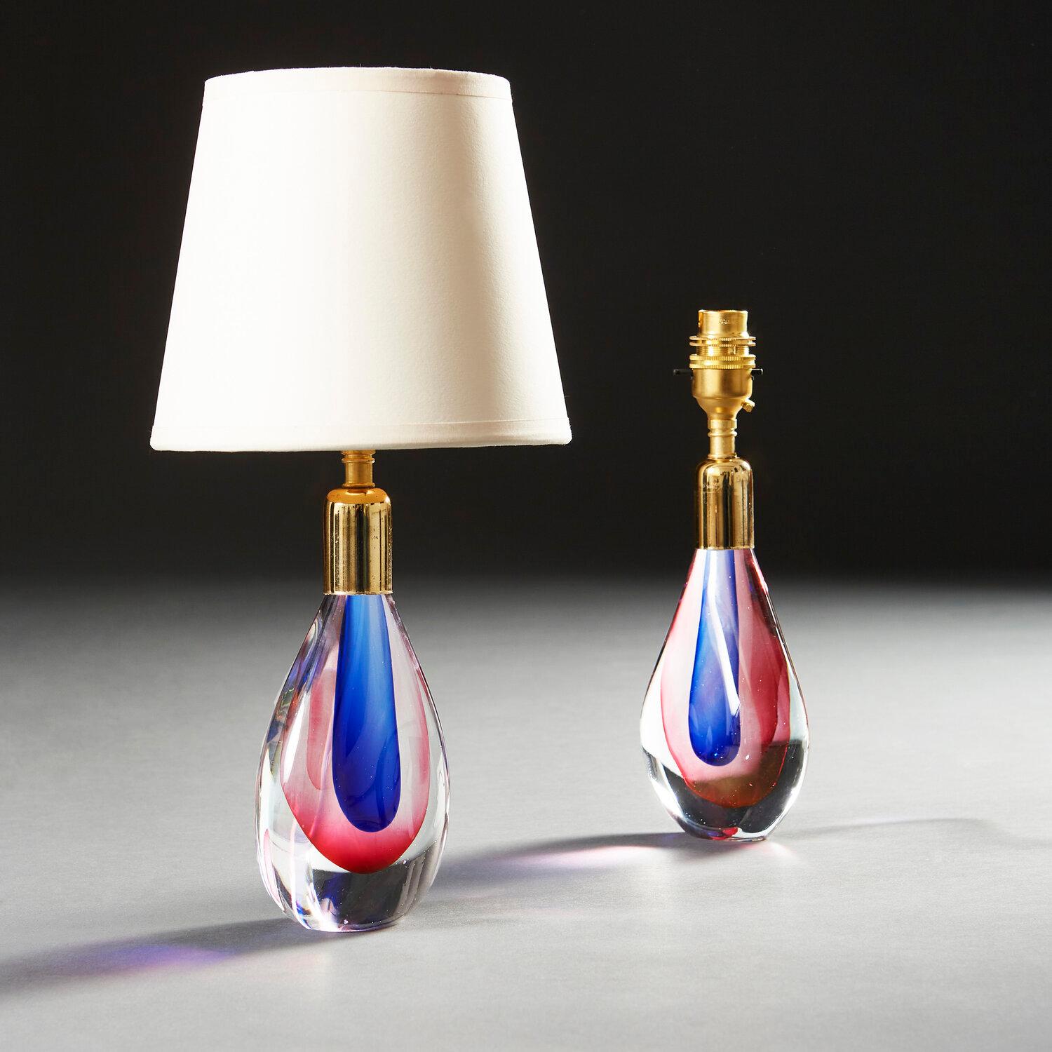 A pair of 1960s Murano glass lamps of teardrop form, with pink and blue to the interior of the glass, with brass collars to the necks.

Please note that the lampshade is not included, and that the lamp is currently wired for the UK.