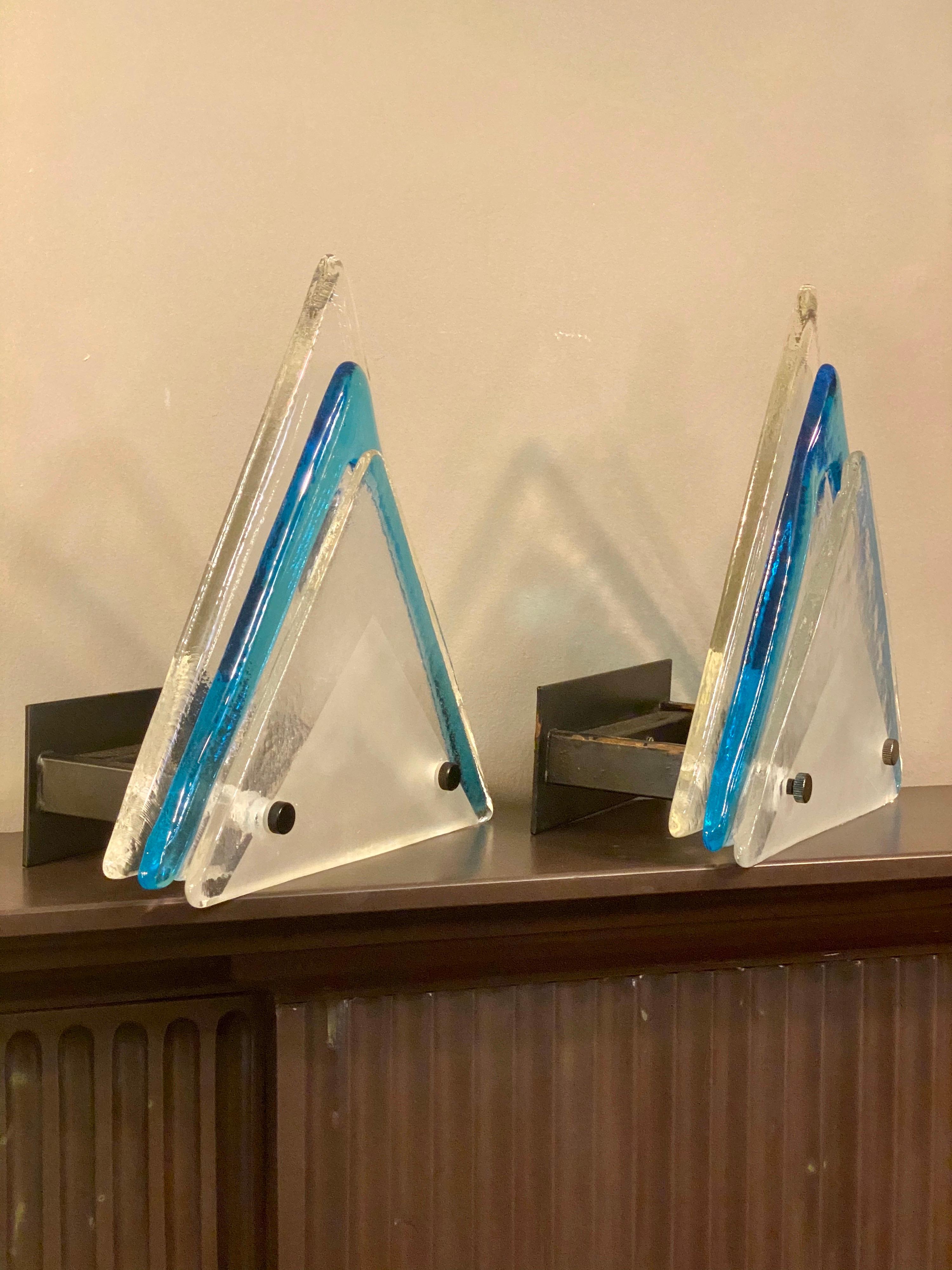 A pair of triangular wall lights consisting of three pieces of Murano glass with the centre piece edged in blue and frosted triangular decoration to front panel. By Mazzega Italy.