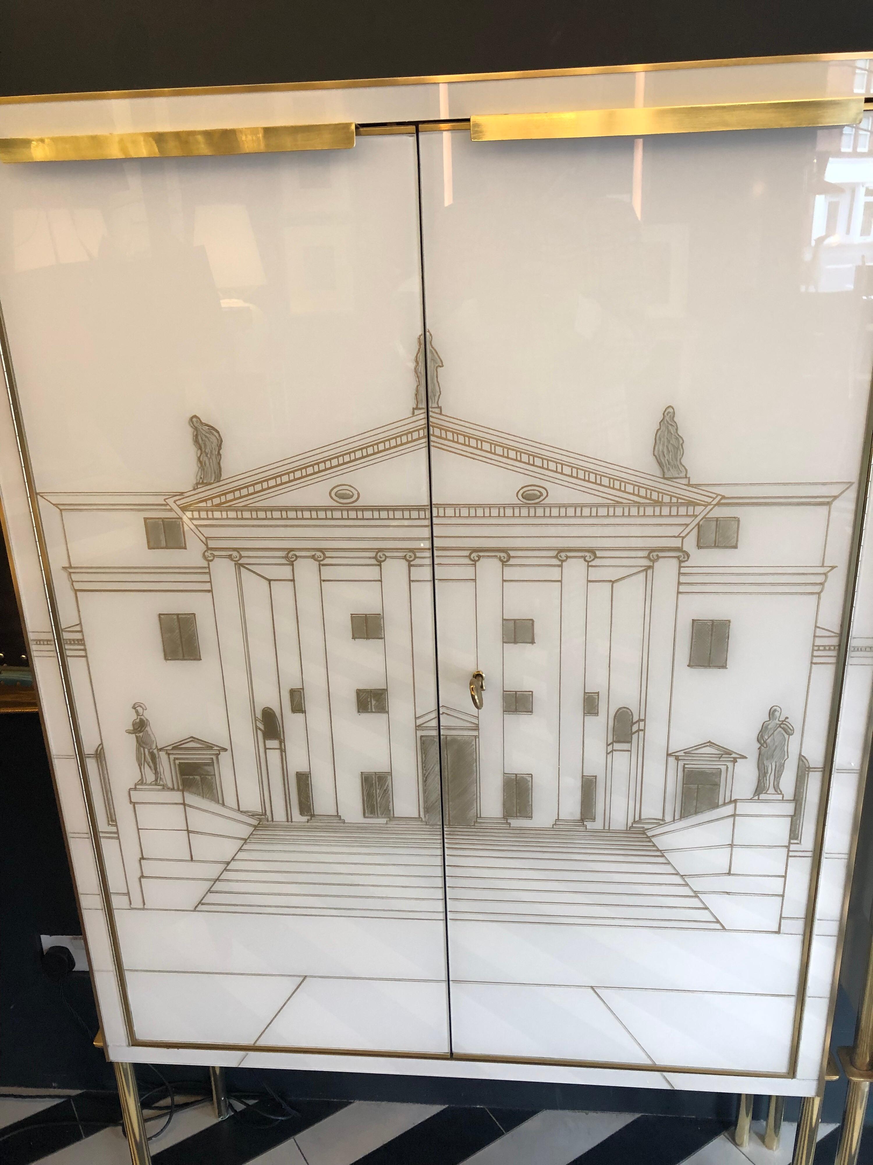 A fabulous pair of exquisite Murano glass cabinets which have been hand painted with 2 different architectural scenes and are completely restored. They have 2 doors with brass top handles and a fully lined interior in grey felt with one shelf. These