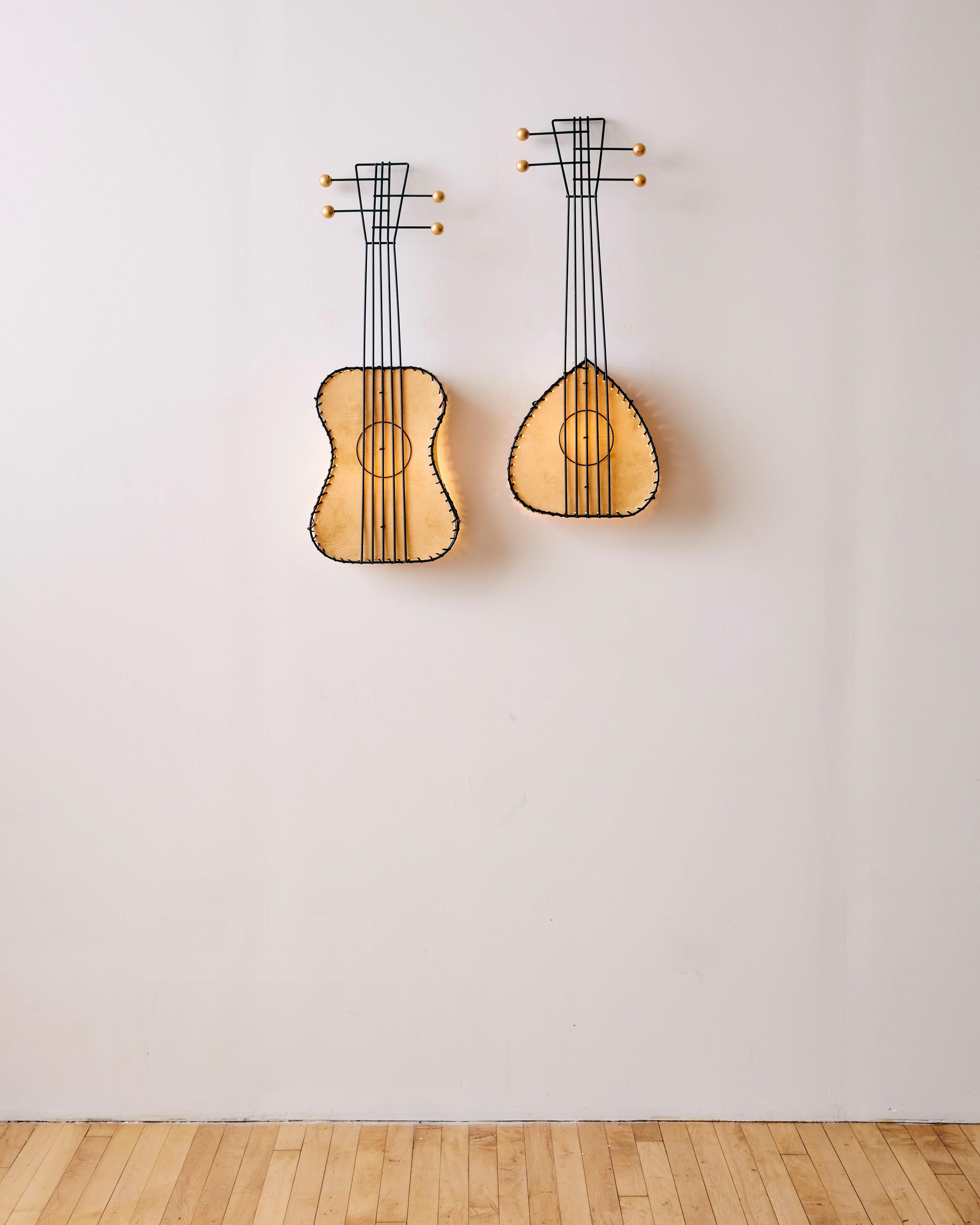 Ein Paar Musikinstrumenten-Wandlampen von Frederic Weinberg in Form einer Gitarre und einer Laute, die aus mit Vellum gefüttertem Pergament, emailliertem Stahl und Blattgold über kugelförmigen Holzdetails bestehen. 

Abmessungen: 30,5 