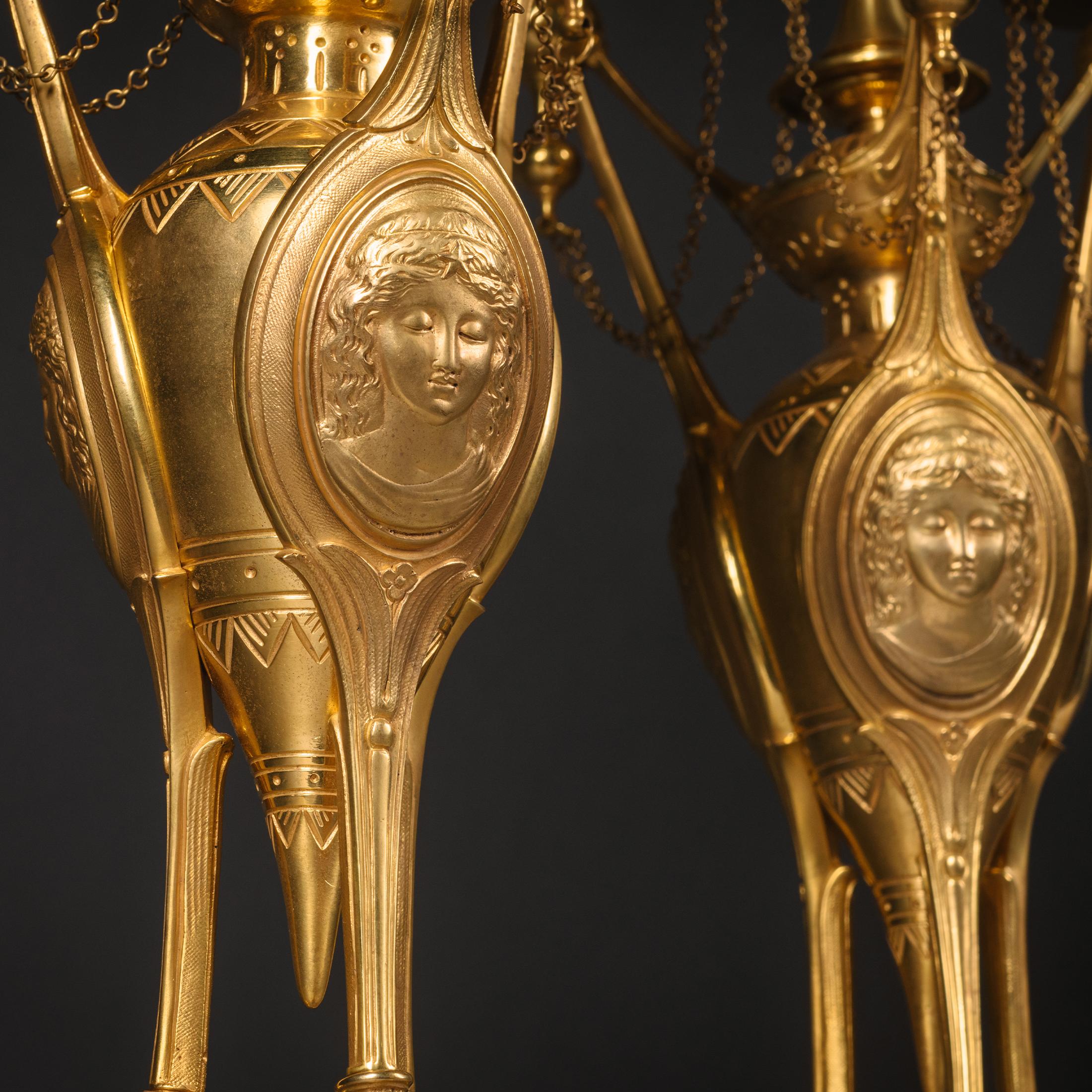 A Pair of Napoleon III Neo-Etruscan Style Gilt-Bronze three-light candelabra by Henri Picard. 

Stamped to the underside of one foot 'H. PICARD'. 

Each candelabrum having a finely cast amphora-shaped body with angular supports,oval portrait