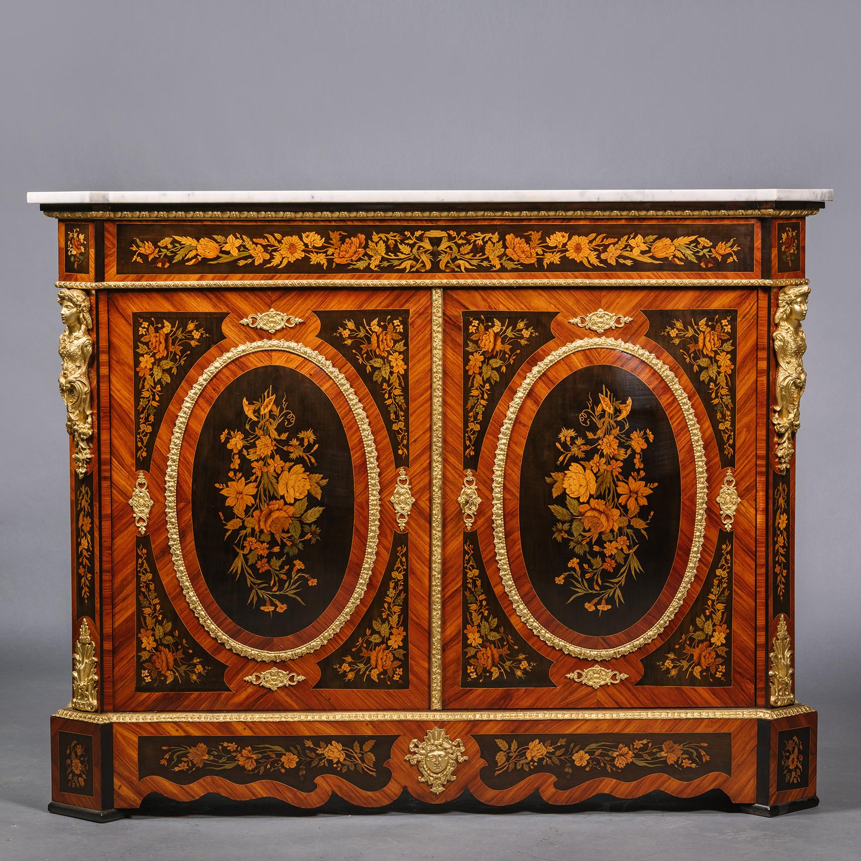 A Pair of Napoleon III Ormolu-Mounted Marquetry side cabinets.

Each cabinet having an eared rectangular marble top above a frieze and doors finely inlaid with elaborate foliate marquetry of floral sprays and bouquets, the cupboard doors opening
