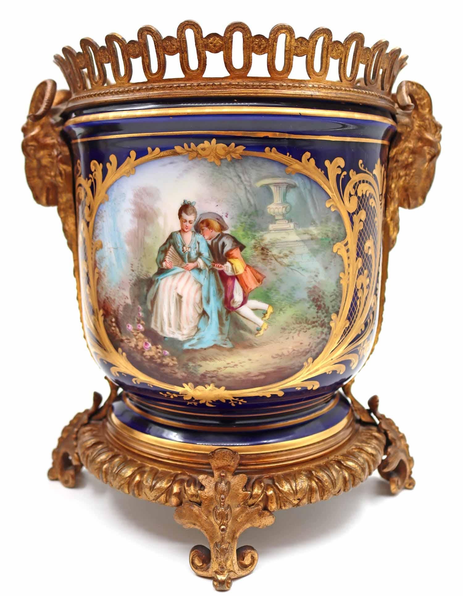 A pair of Napoleon III porcelain and gilt bronze planters, 19th century.
Measures: H: 24 cm, W: 24 cm, D: 19 cm.
