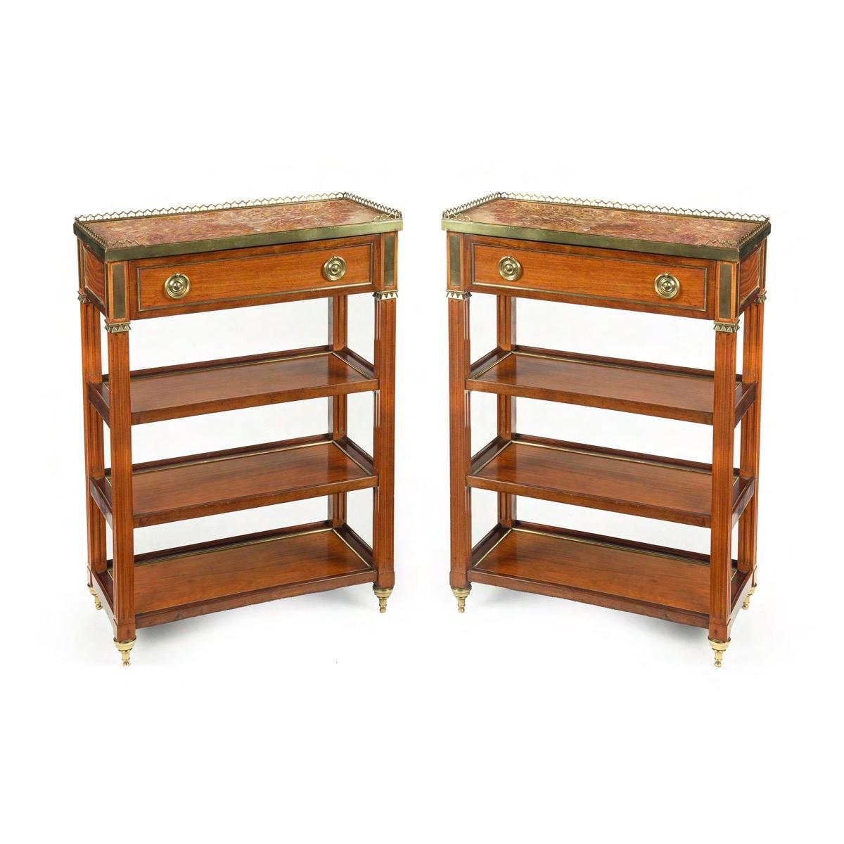A pair of Napoleon III satinwood side tables or bedside tables, each of rectangular form with a marble top (repaired) surrounded by a brass pierced gallery, all above a single frieze drawer and three shelves, decorated throughout with unusual brass