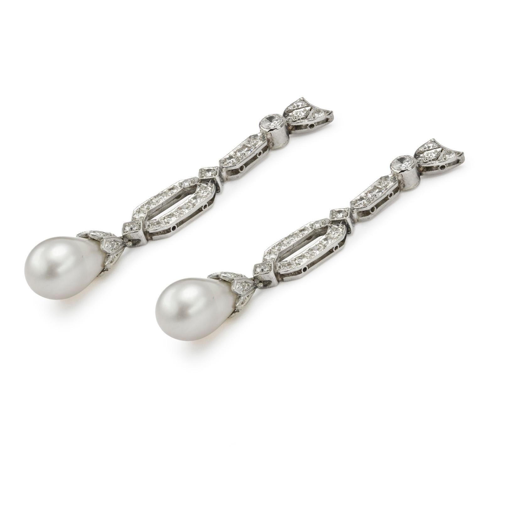 A pair of natural saltwater pearl and diamond drop earrings, each pearl measure approximately 7.3 x 11.5 mm and 7.2 x 11.0 mm, each with eight-cut diamond encrusted white gold caps, suspended by a hexagonal openwork diamond-encrusted plaque of a