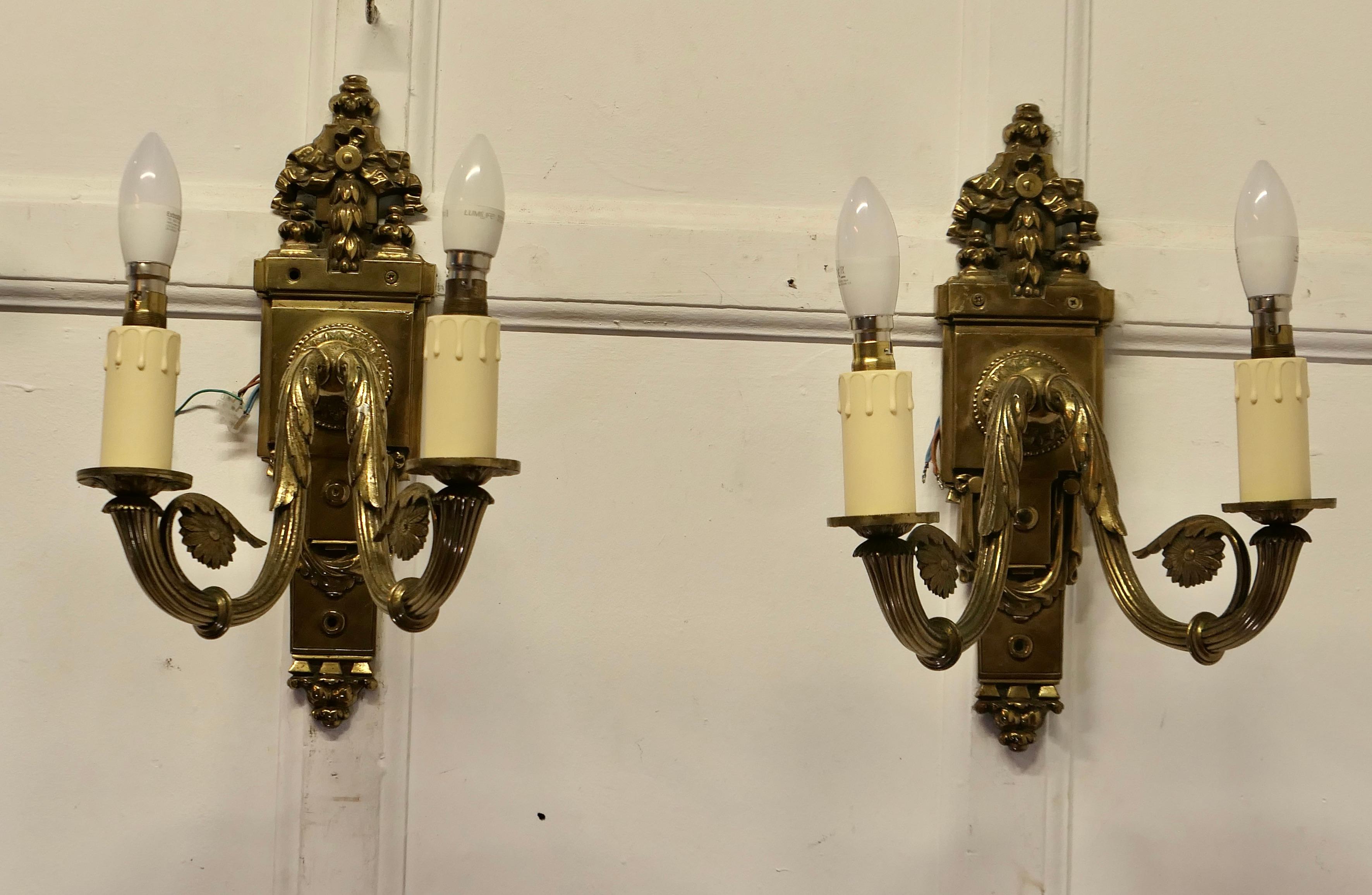 A Pair of Neo Classical Large Brass Twin Wall Lights

This is a very attractive pair of lights they are very heavy and decorative each of the light fittings have 2 sconces 

The lights are in good vintage condition and working, they will have to be