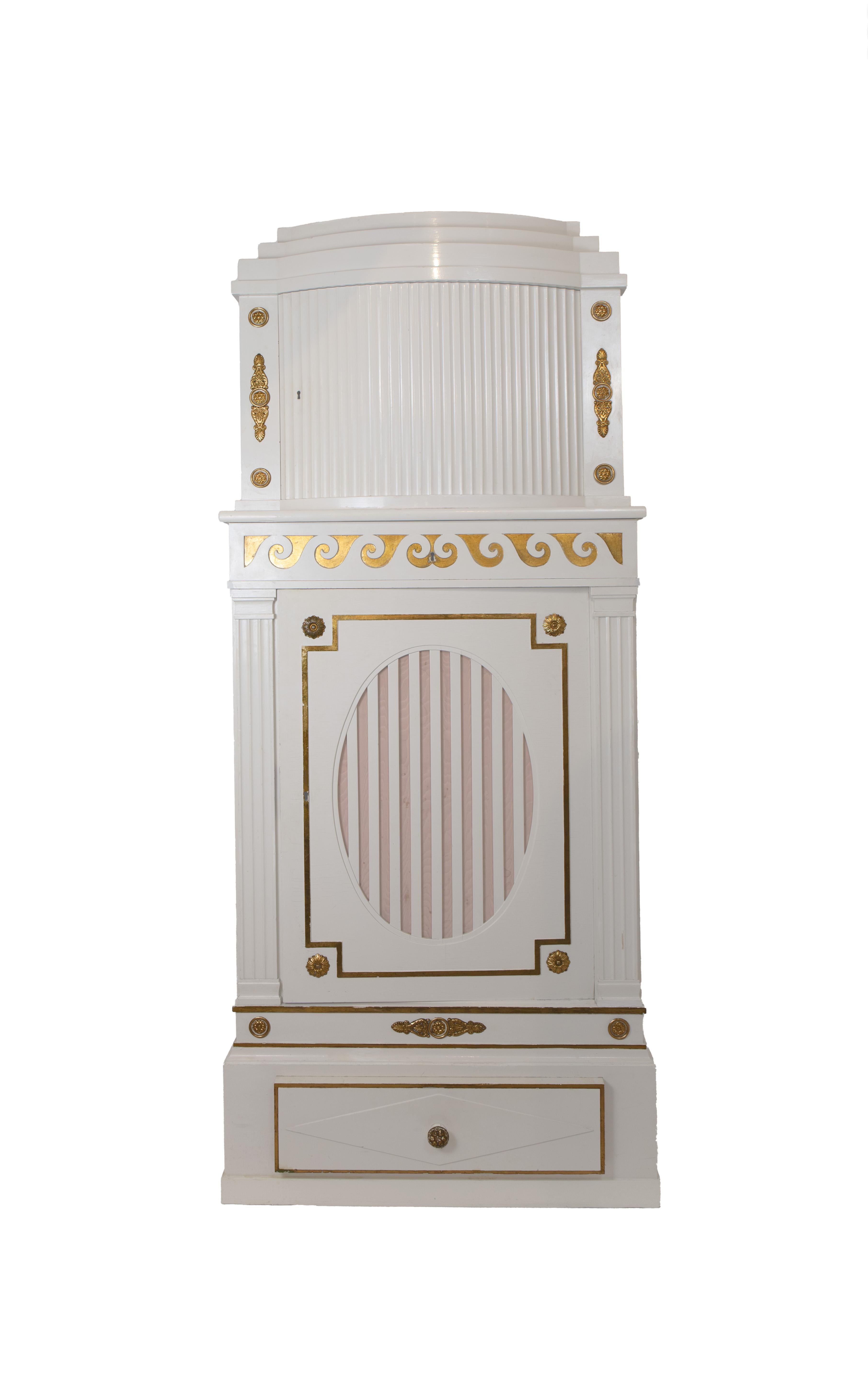 A pair of two-part cabinets in a Neoclassical design. The lower cabinet with oval pierced fret panel backed with fabric, concealing multiple mahogany drawers fit for cutlery and dining accessories above larger drawer with diamond patterned raised