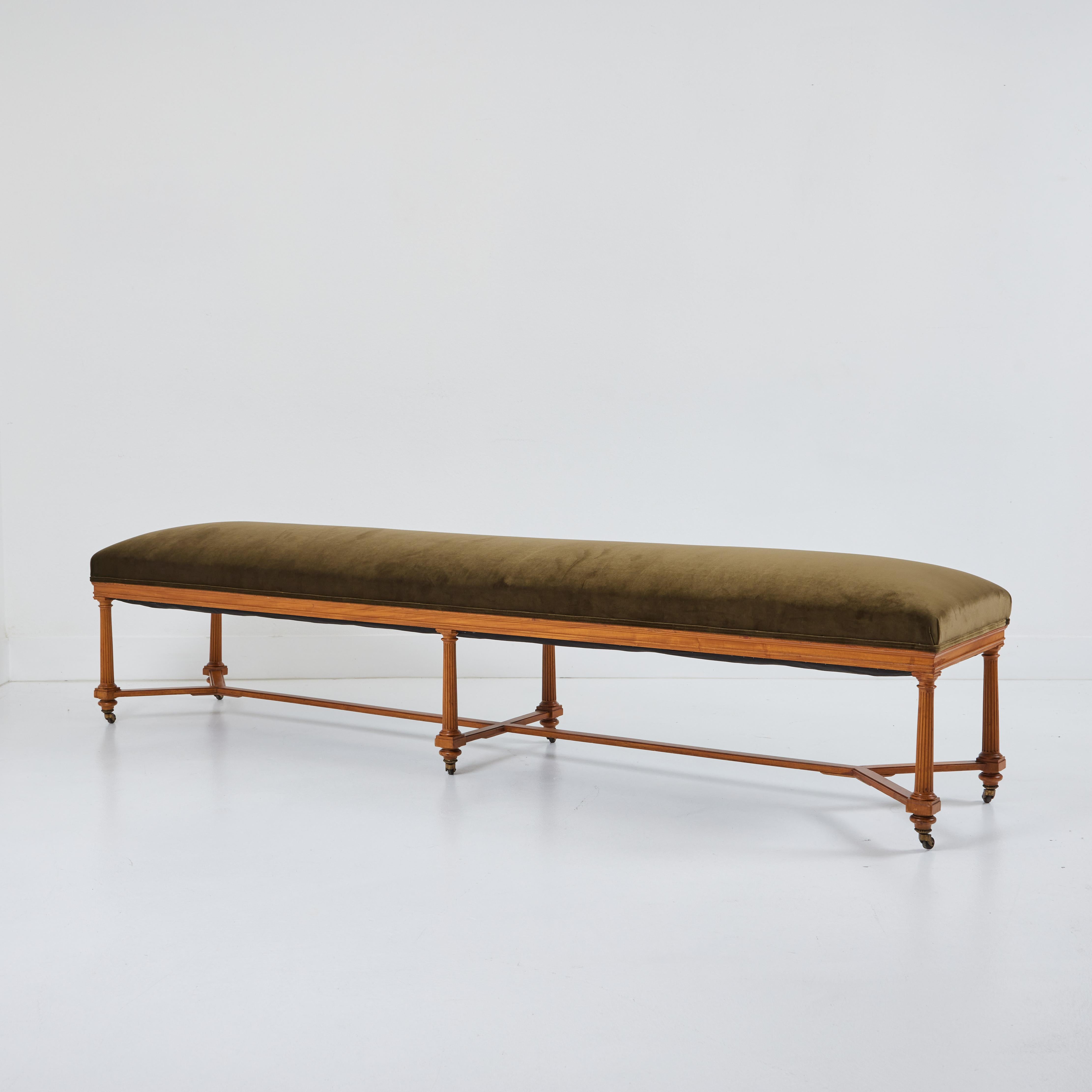 This grand and stately pair of benches measure a generous eight feet long and are nearly two feet wide.  They have been newly upholstered in a dark olive/green Jab velvet and are finished with a double welt. The beautifully mellowed original finish