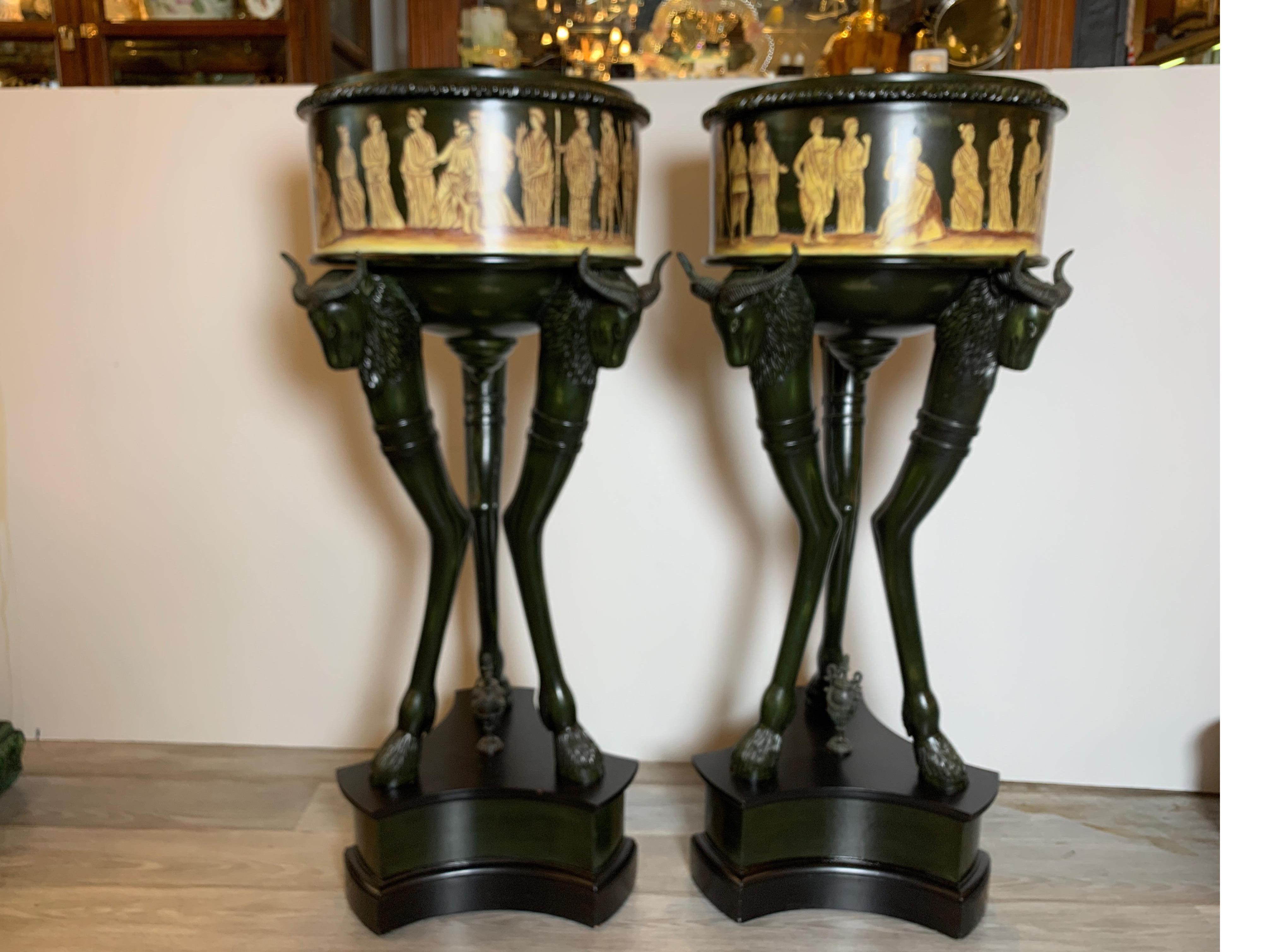 An exotic pair of neoclassical tall planters by Maitland Smith. The planters with hand painted neoclassical figures around the outside supported by three horned figures with hoofs at the bottom. These also have the original patinated copper inserts.