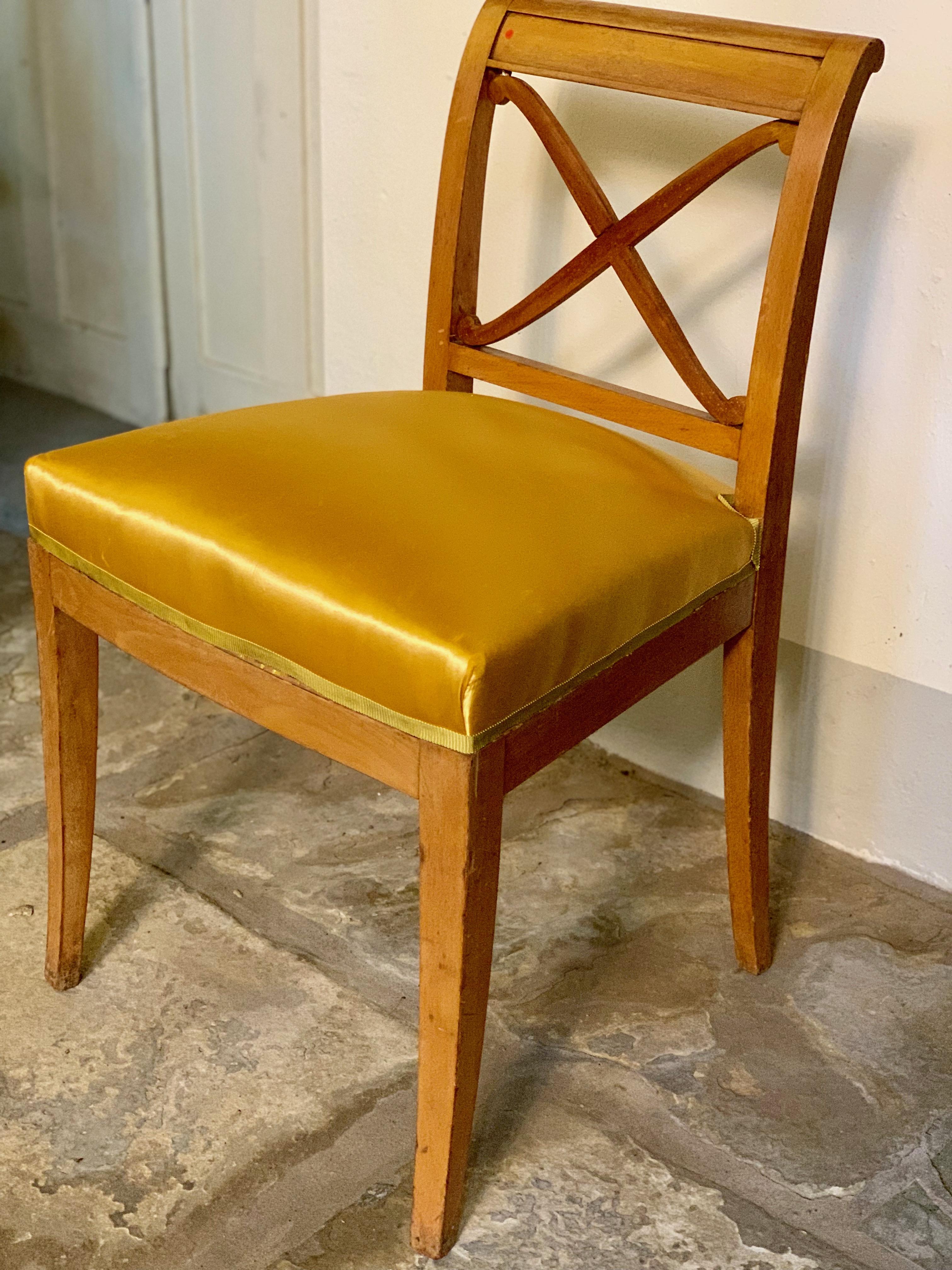 A pair of Neoclassical Revivalist chairs, circa 1940 after the tastes of Napoleon Bonaparte. The legs are simply done and the backs are finished with a classic X crossing. The cushions are of golden satin, finished with trim.