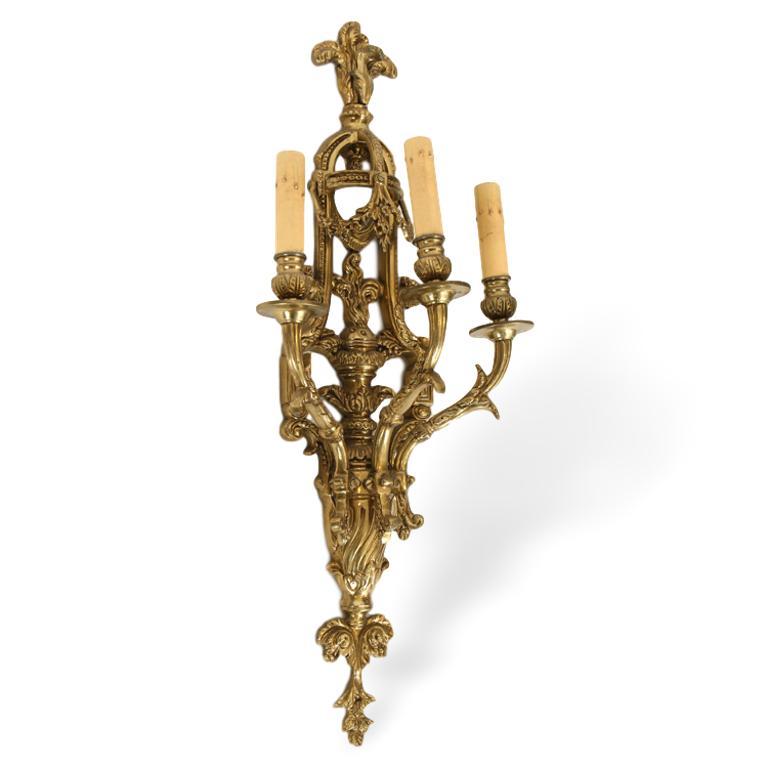 A pair of Neoclassical style bronze three arm wall sconce lights having central flamed finials flanked by rooster heads, French, circa 1910.

Dimensions: Ht: 26