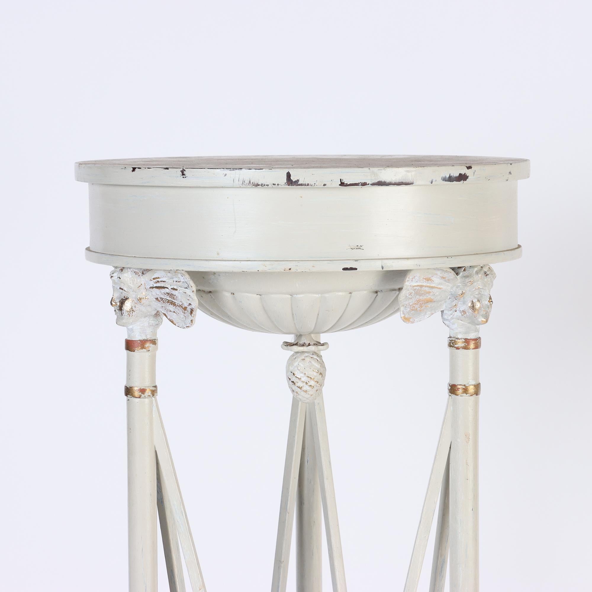 A pair of tall Neoclassical style white painted with partial gilt pillars/pedestals resting on a concave tripartite platform.