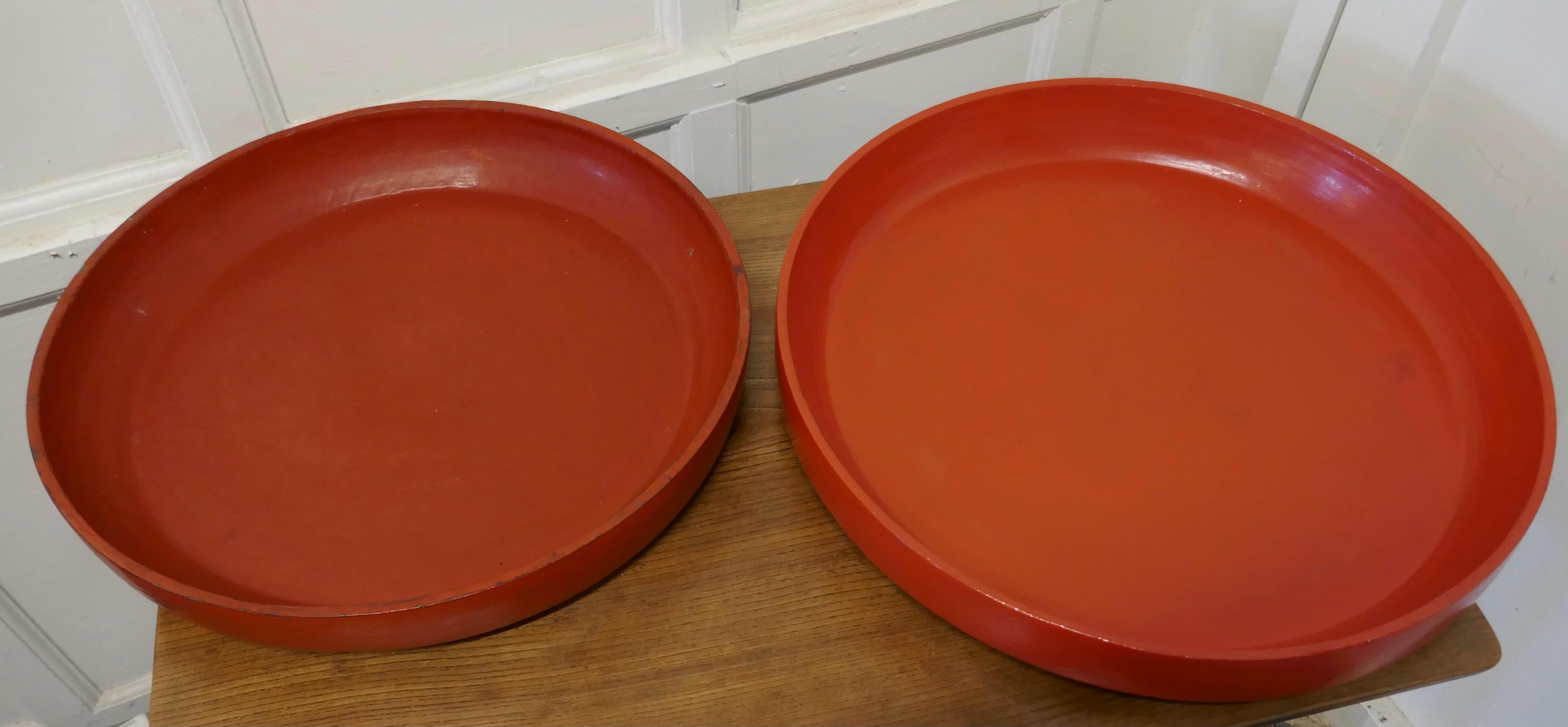 Paire de plats d'art populaire nord-africain faits à la main en ocre rouge

2 jolis grands plats, peints en ocre rouge, tournés à la main à partir d'une seule pièce de bois

La finition peinte est dure et très durable 
Le plus grand plat mesure