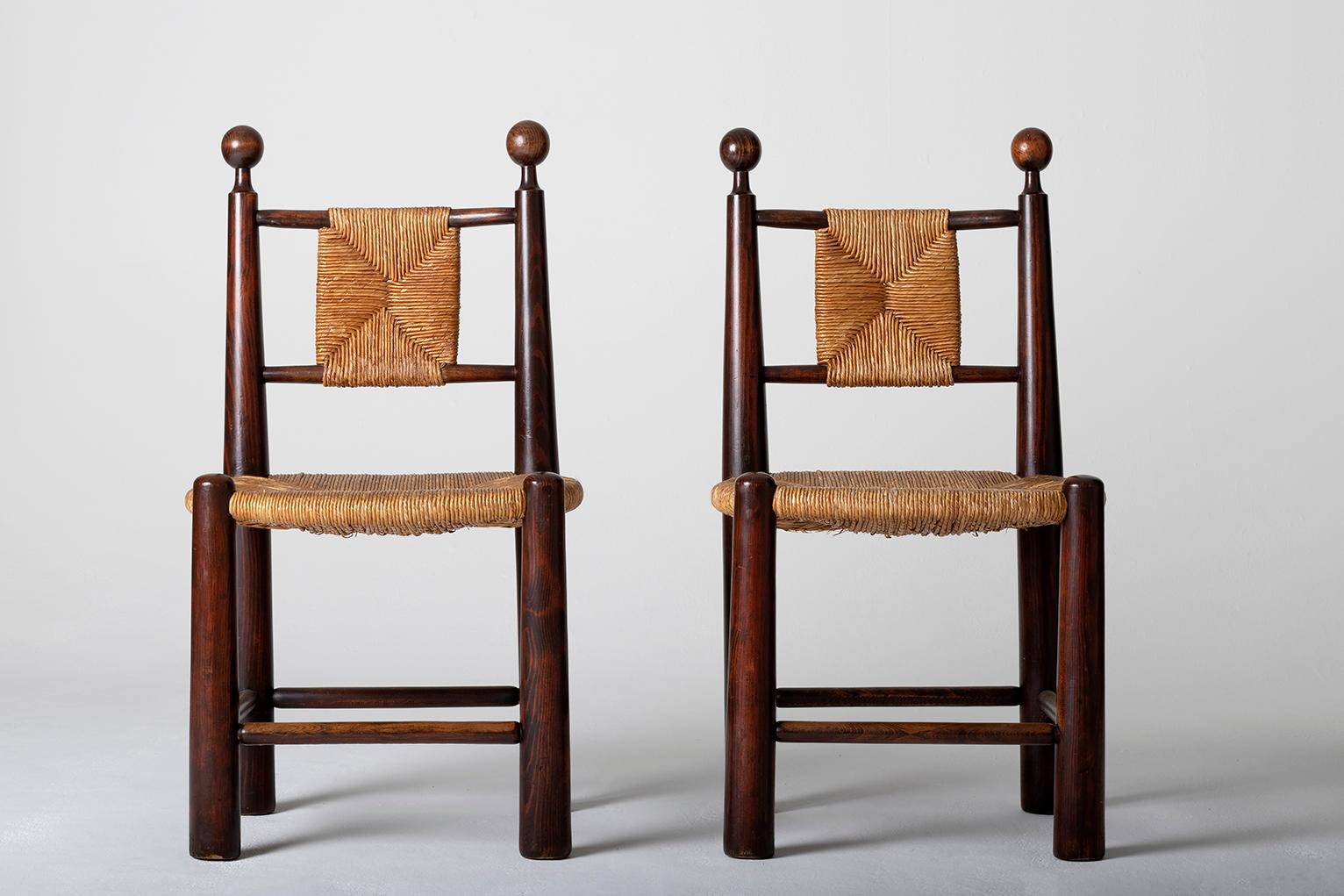 A pair of oak and straw seat and 'quilles' back chairs, in the manner of Jean Royère (1902-1981).
France, circa 1955.