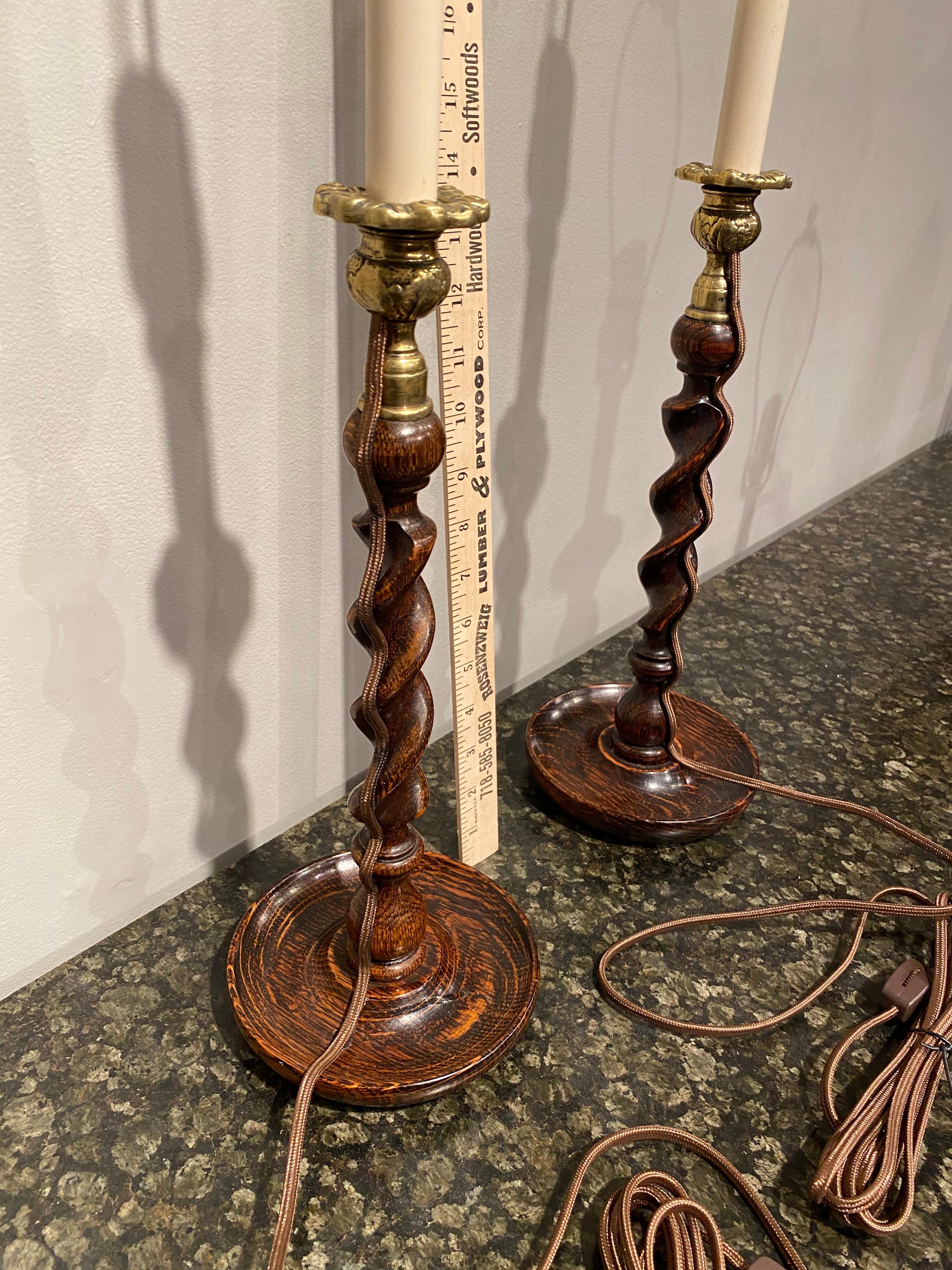 A pair of oak barley twist candlestick lamps.

 
