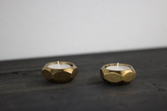 a pair of octagonal brass candle holders by Pierre Forsell for Skultuna