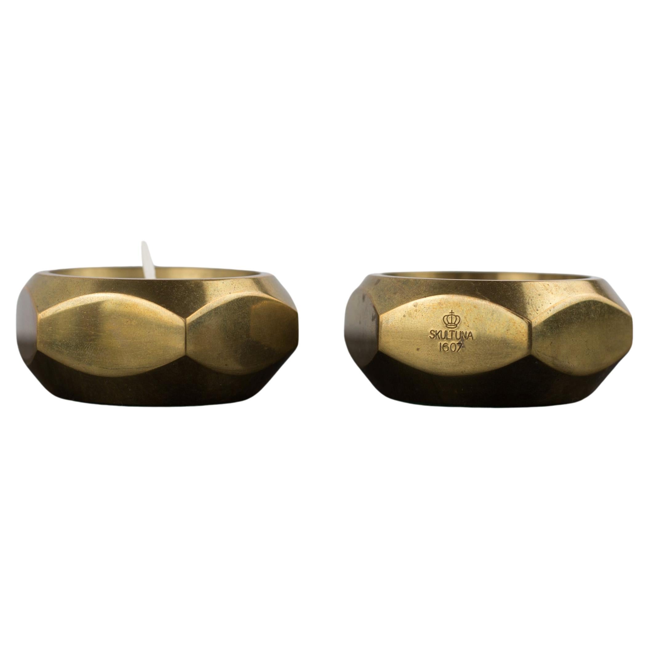 a pair of octagonal brass candle holders by Pierre Forsell for Skultuna