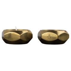 a pair of octagonal brass candle holders by Pierre Forsell for Skultuna