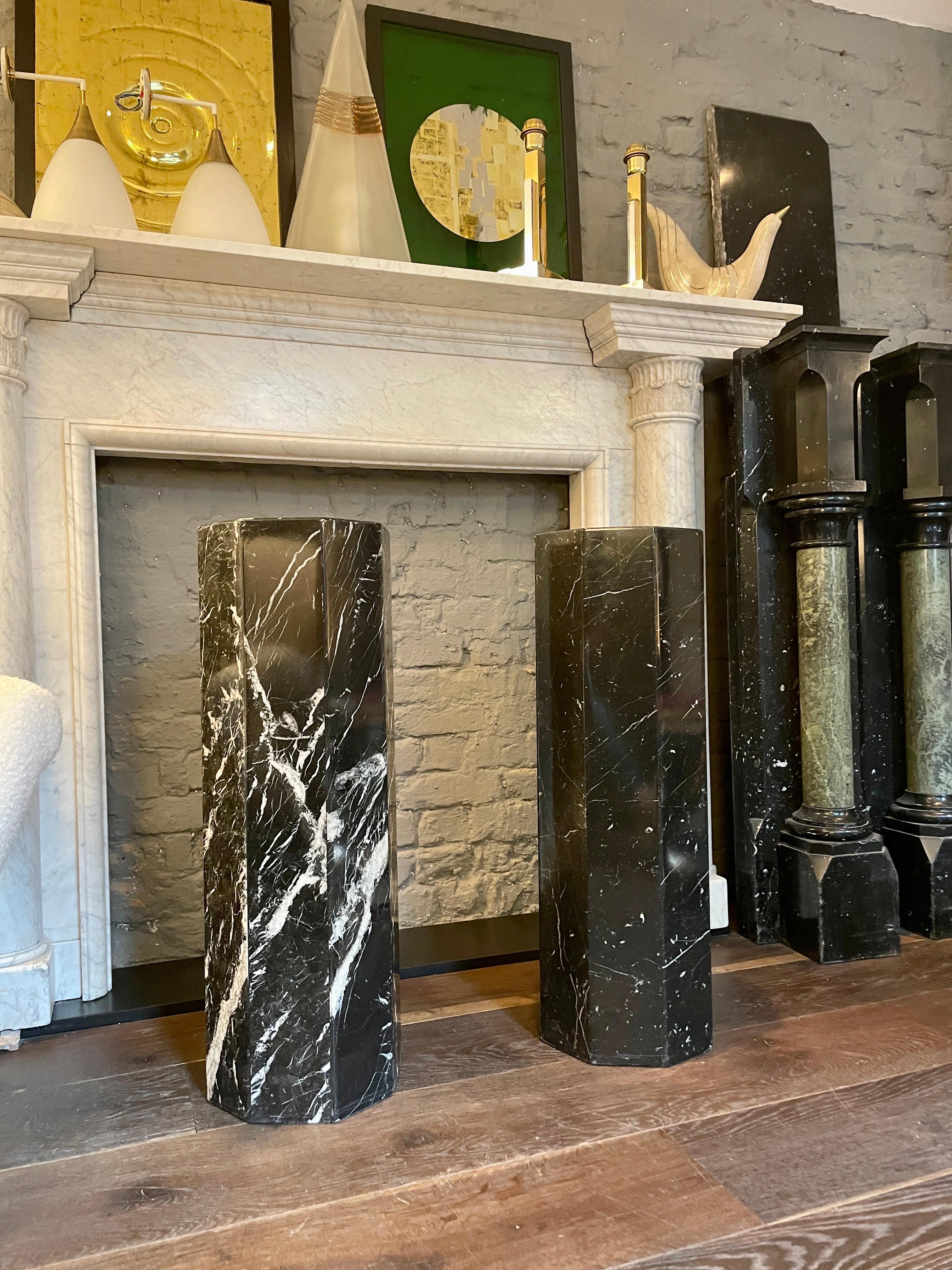 An unusual pair of octagonal pedestal or columns in veined Nero Marquina marble. Simple in form yet good scale and proportions. Would work well in either contemporary or traditional setting. European late 20th century.