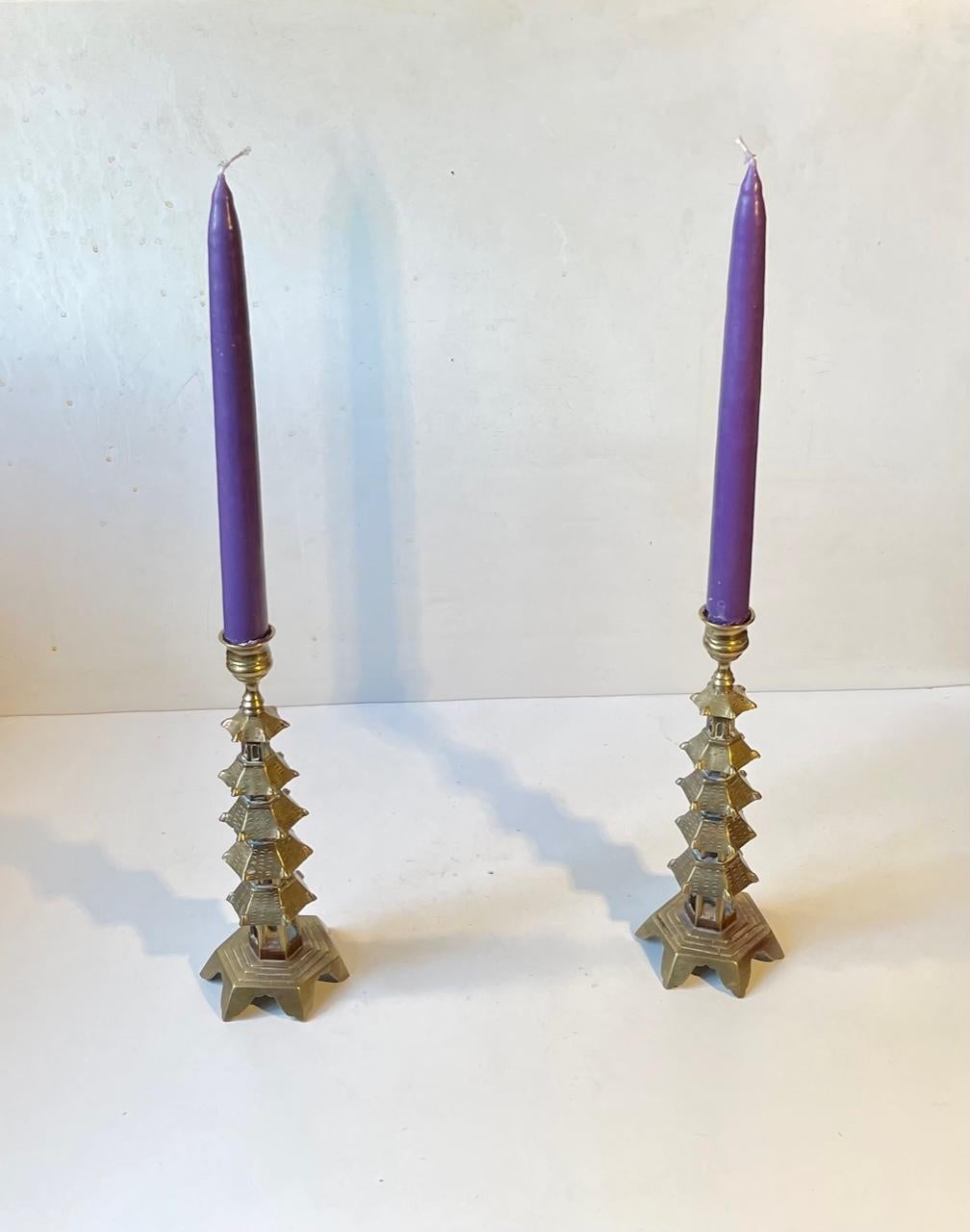 A pair of pagoda shaped candleholders in brass. Made in China before 1969 where the previous owner bought them. They can be installed with regular sized candles. Measurements: H: 23 cm, W: 8/3.3 cm (base/top).