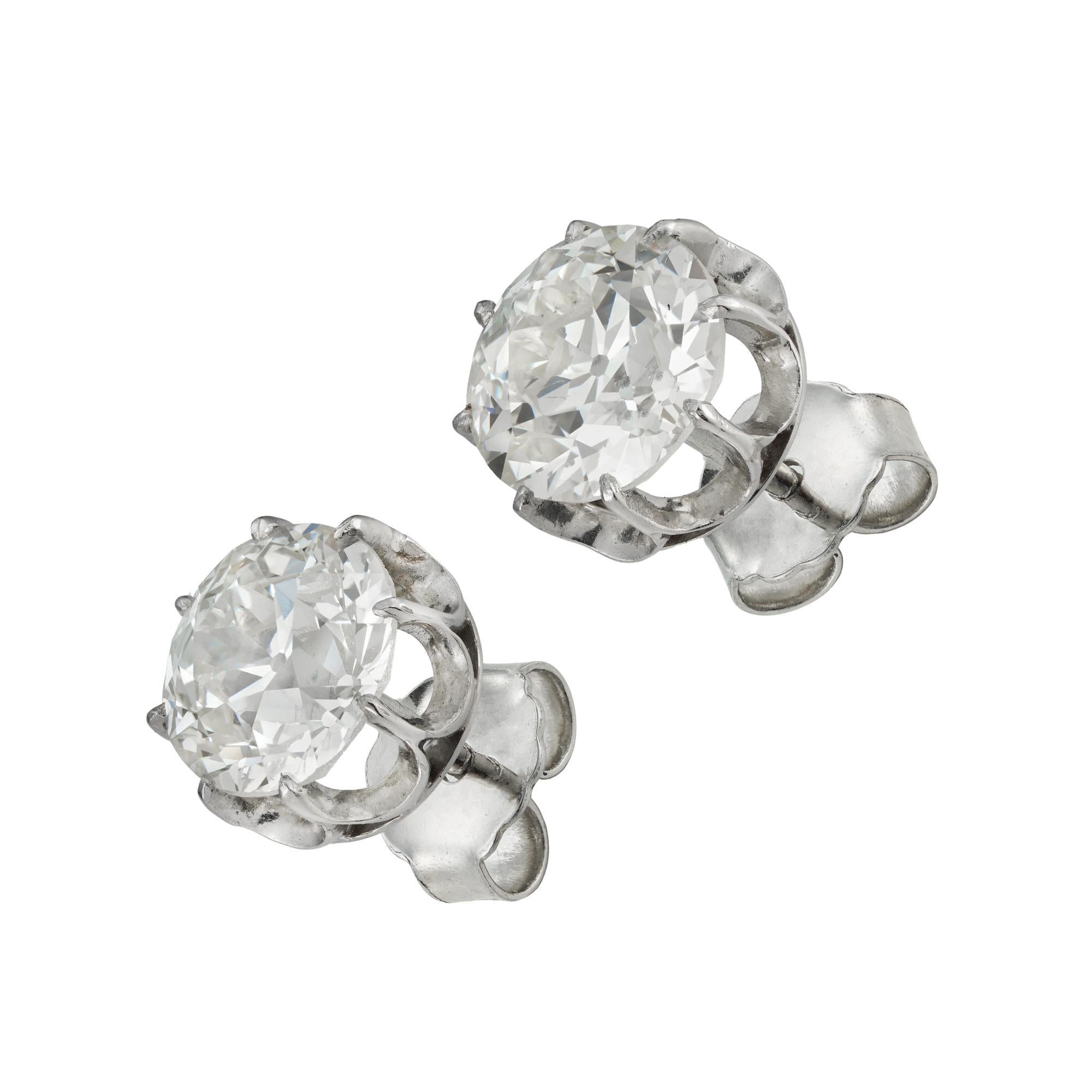 A pair of old European-cut diamond stud earrings, the diamonds weighing 2.48 carats and 2.54 carats, accompanied by GCS report stating that both are of M colour and VS1 clarity, each stone eight claw-set to a platinum mount with post and scroll