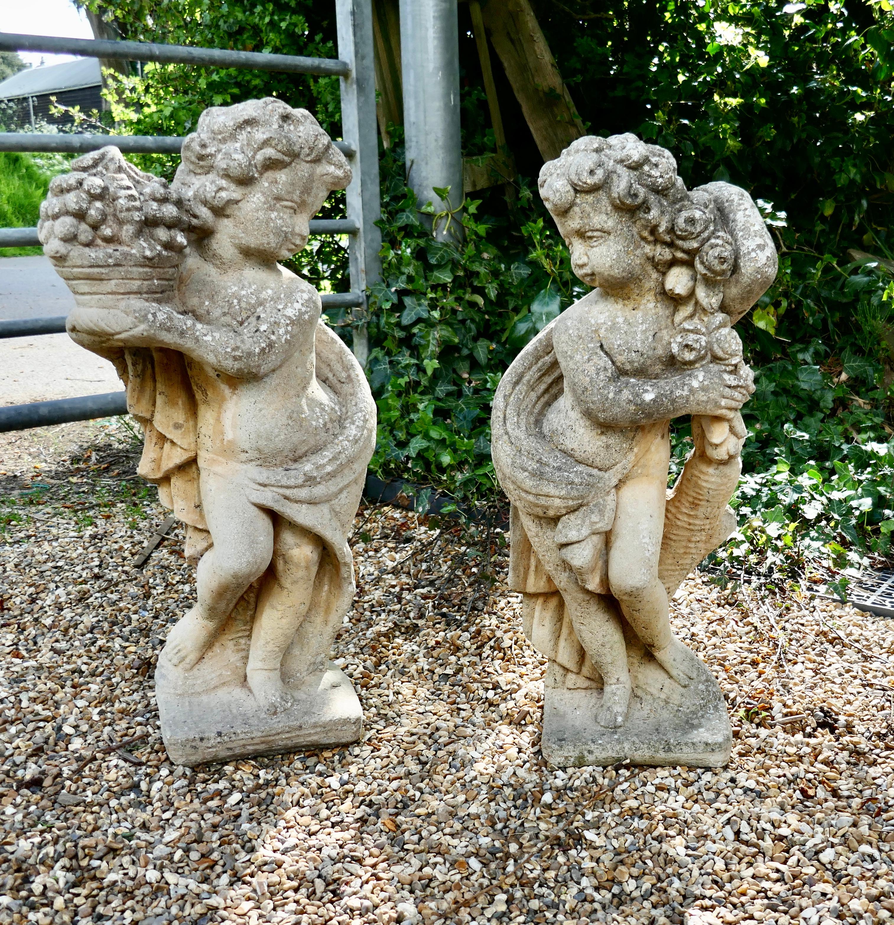 A Pair of Old Weathered Classical Flower Children Statues 

These are lovely old statues, they are a boy and girl, he is holding a basket of Fruit and she has a Rose Garland they have cute facial expressions
The children face one another and have