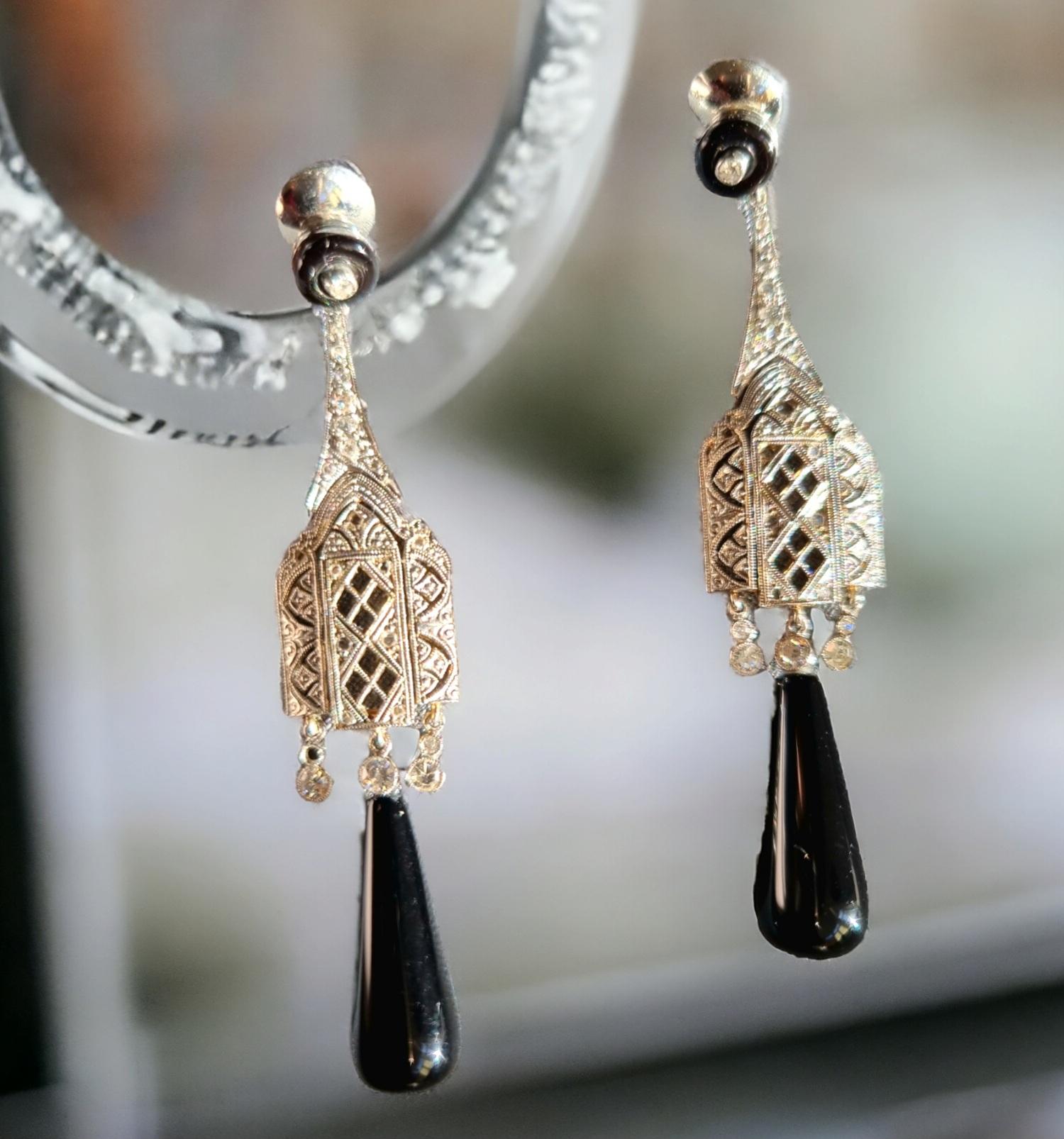 Onyx and Diamond Pendant Earrings
A pair of Onyx and Diamond Earrings. Art-Deco style. Mounted in platinum with delicate filigree and mille-grain craftmanship.
Length: 6.5cm; width: 1.5cm.
Unmarked, tested as Platinum.
Total weight: 14.05 grams.
We