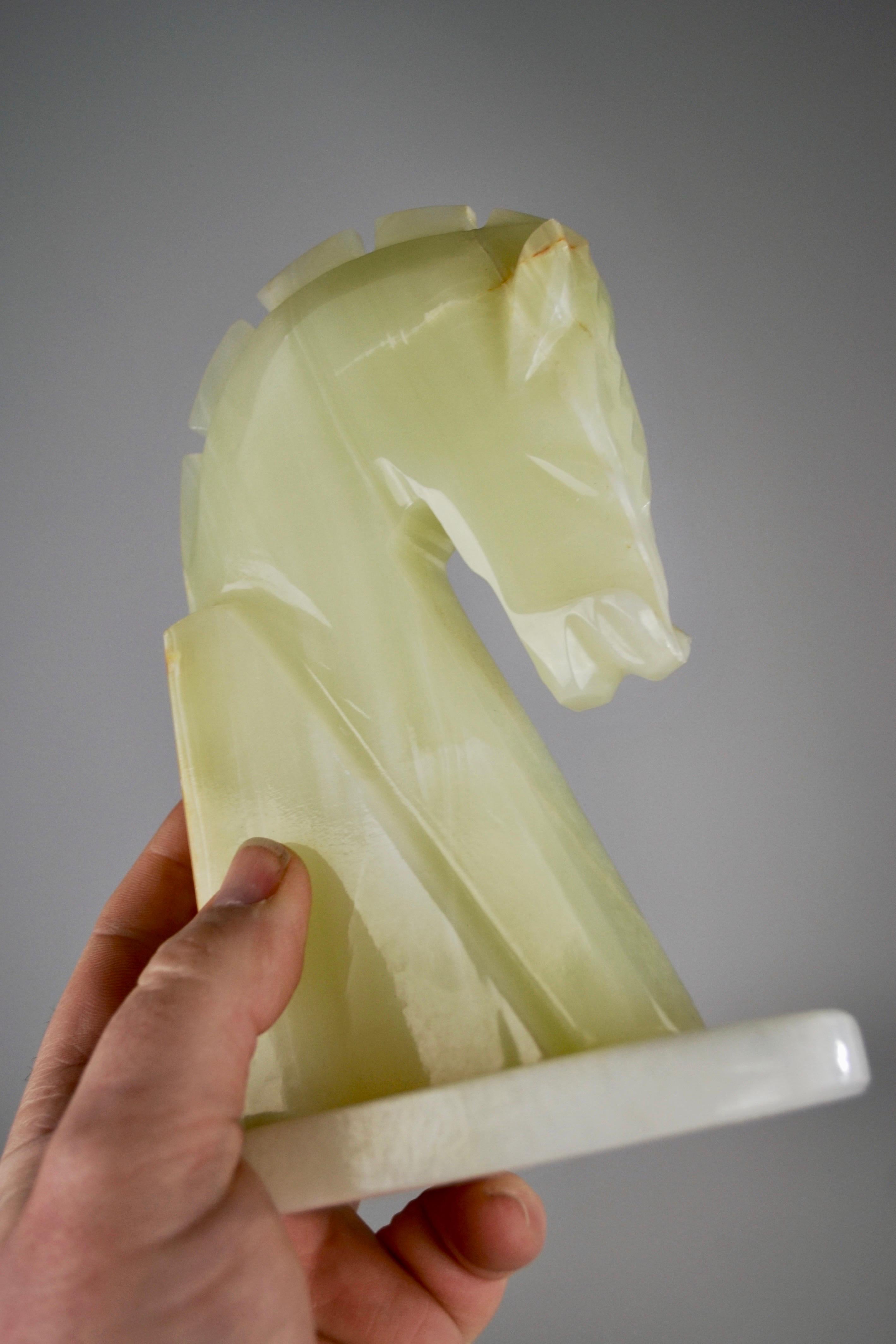 An elegant pair of sculpted onyx bookends, featuring finely crafted horse heads. Dating from the 1970s, these unique pieces stand out for their exquisite craftsmanship and the natural beauty of onyx with its subtly veined green hues. Both decorative