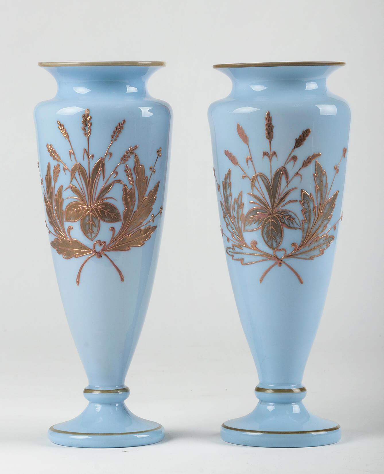 Ein schönes Paar antiker Vasen. Hergestellt aus Opalglas, in einer besonderen Farbe, die zwischen violett-lila und himmelblau liegt. Die Vasen sind handbemalt mit einem Reliefdekor aus Goldfarbe. Die Ränder sind mit einfachen goldfarbenen Linien
