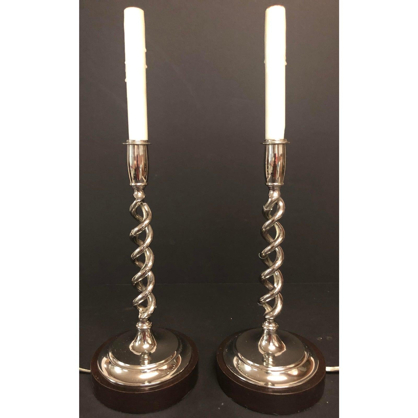 A pair of open barley twist candlestick lamps. Beautiful 19th century nickel over bronze hollow twist candlesticks. Wired for electricity with exposed wire. Mounted on later tailored walnut stained bases. Clear silver wire with brown in- line on/off